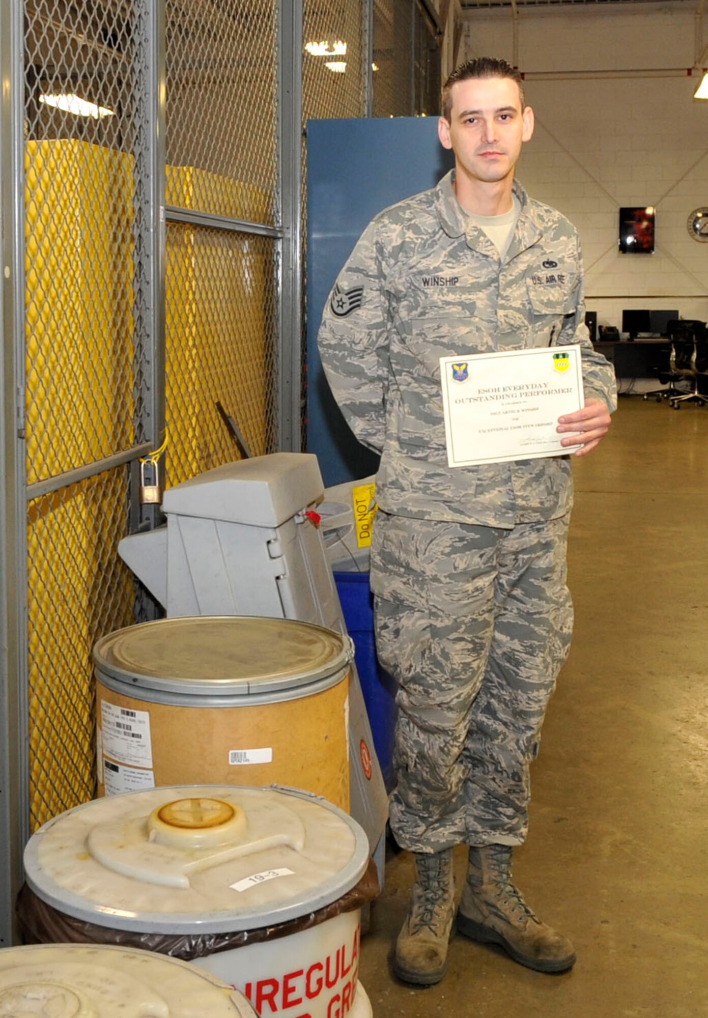 Staff Sgt. Arthur Winship poses for a photo next to hazardous material 55-gallon drums on Barksdale Air Force Base, Jan. 17, 2014. Winship won an outstanding performer award for high inspection scores on HAZMAT storage and disposal.(U.S. Air Force Photo/Airman 1st Class Benjamin Raughton)