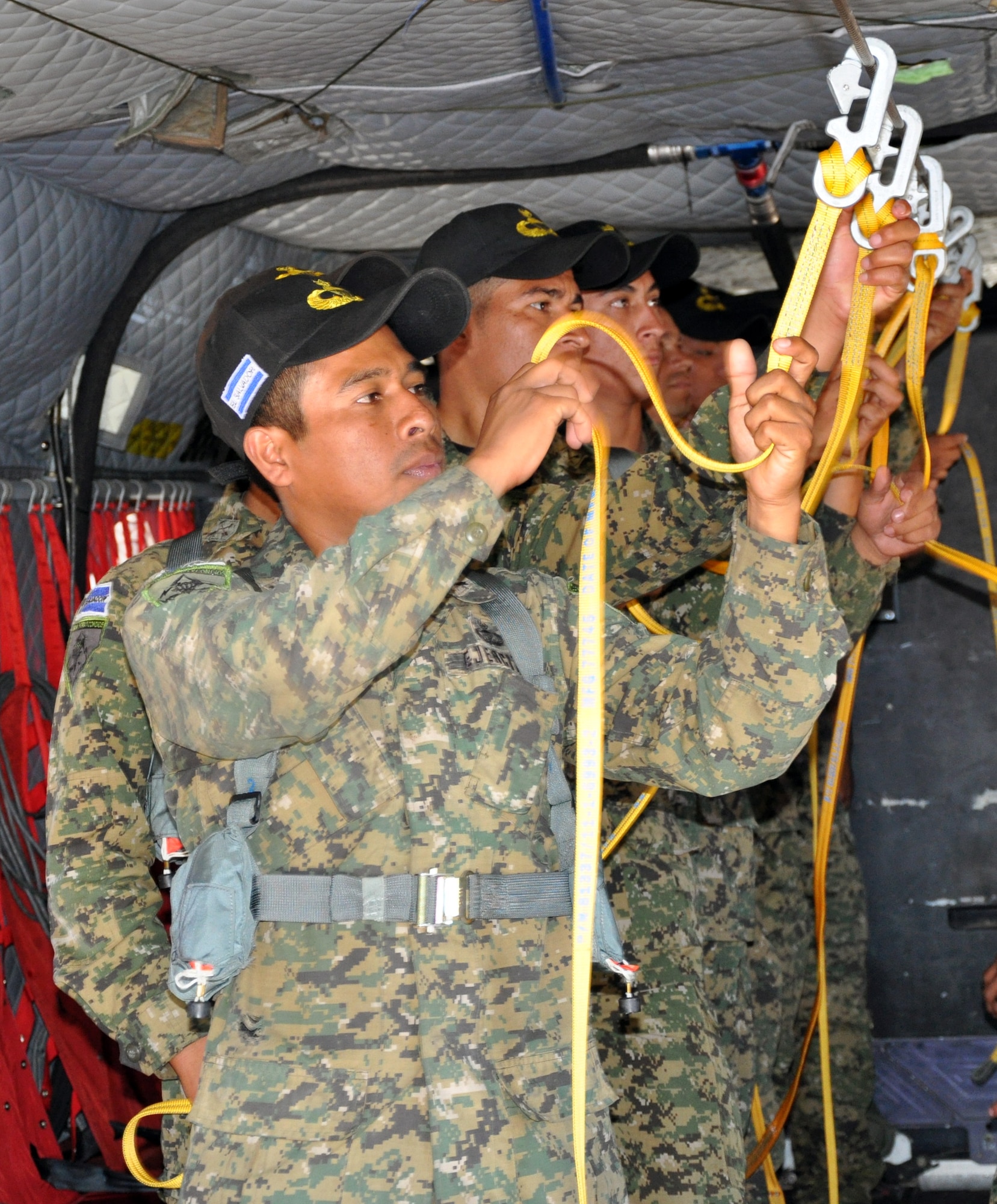 El Salvadoran military members rehearse to prepare to jump from the ramp of a CH-47 Chinook helicopter at an altitude of 1,250 feet during a joint airborne operations training exercise conducted by U.S. Special Forces and El Salvadoran servicemembers over Lake Ilopango, El Salvador, Jan. 21, 2014.  U.S. Special Forces from the 7th Special Forces Group (Airborne) conducted the training exercise alongside members of the El Salvadoran military.  The joint-training, overwater static jump allowed members from both nations to maintain currency while strengthening the relationship between the U.S. and El Salvadoran forces.  Joint Task Force-Bravo’s 1-228th Aviation Regiment provided aerial support for the exercise, flying each chalk of jumpers from the Ilopango International Airport to the drop zone over Lake Ilopango.  (U.S. Air Force photo by Capt. Zach Anderson)