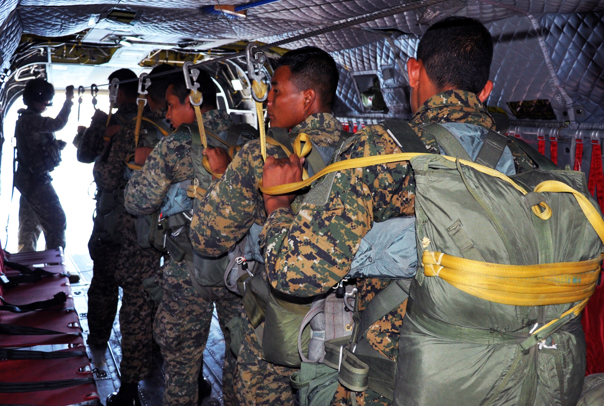 El Salvadoran military members wait to jump from the ramp of a CH-47 Chinook helicopter at an altitude of 1,250 feet during a joint airborne operations training exercise conducted by U.S. Special Forces and El Salvadoran servicemembers over Lake Ilopango, El Salvador, Jan. 21, 2014.  U.S. Special Forces from the 7th Special Forces Group (Airborne) conducted the training exercise alongside members of the El Salvadoran military.  The joint-training, overwater static jump allowed members from both nations to maintain currency while strengthening the relationship between the U.S. and El Salvadoran forces.  Joint Task Force-Bravo’s 1-228th Aviation Regiment provided aerial support for the exercise, flying each chalk of jumpers from the Ilopango International Airport to the drop zone over Lake Ilopango.  (U.S. Air Force photo by Capt. Zach Anderson)