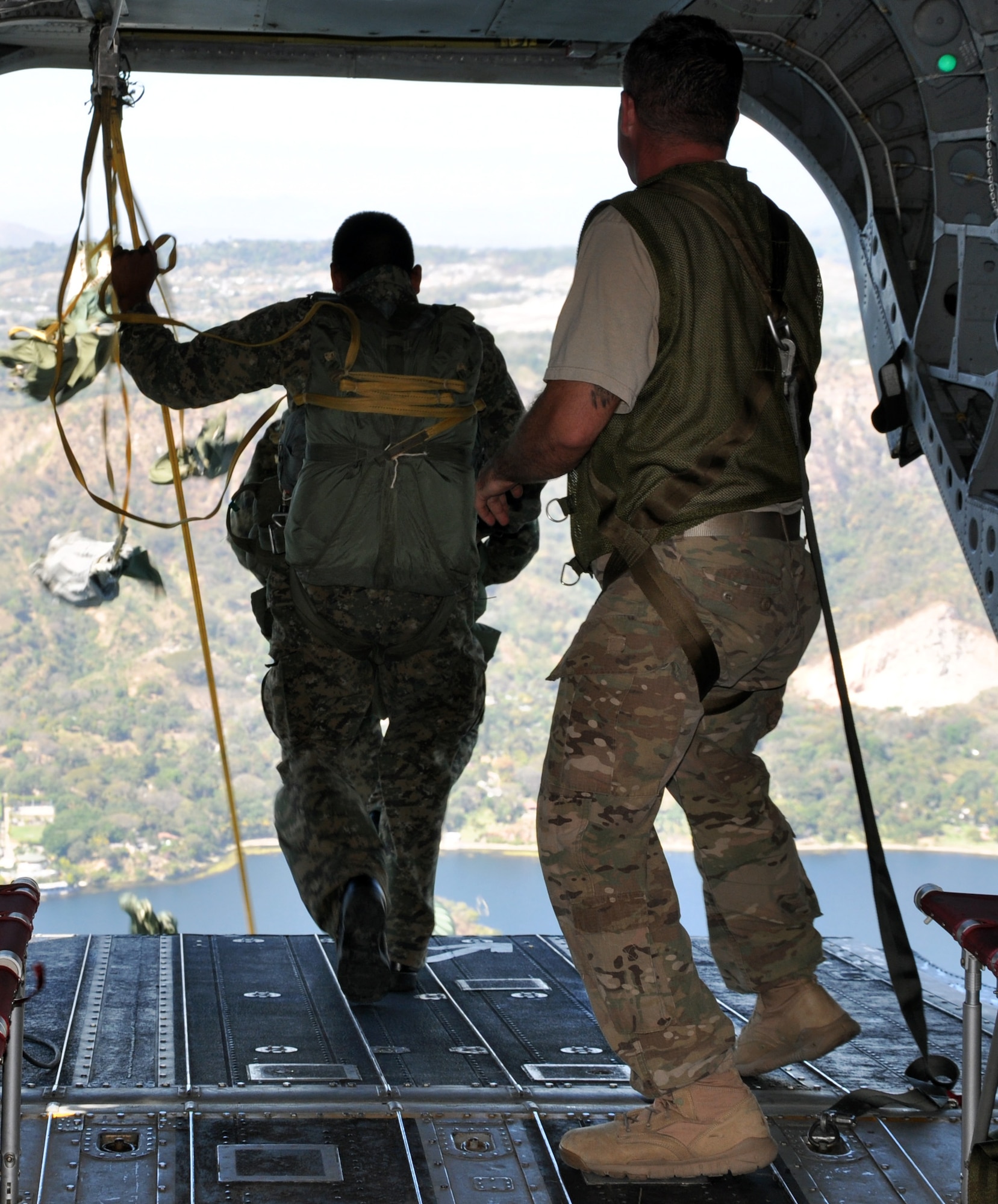 A jumpmaster looks on as a member of the El Salvadoran military jumps from the ramp of a CH-47 Chinook helicopter during a joint airborne operations training exercise conducted by U.S. Special Forces and El Salvadoran servicemembers over Lake Ilopango, El Salvador, Jan. 21, 2014.  U.S. Special Forces from the 7th Special Forces Group (Airborne) conducted the training exercise alongside members of the El Salvadoran military.  The joint-training, overwater static jump allowed members from both nations to maintain currency while strengthening the relationship between the U.S. and El Salvadoran forces.  Joint Task Force-Bravo’s 1-228th Aviation Regiment provided aerial support for the exercise, flying each chalk of jumpers from the Ilopango International Airport to the drop zone over Lake Ilopango.  (U.S. Air Force photo by Capt. Zach Anderson)