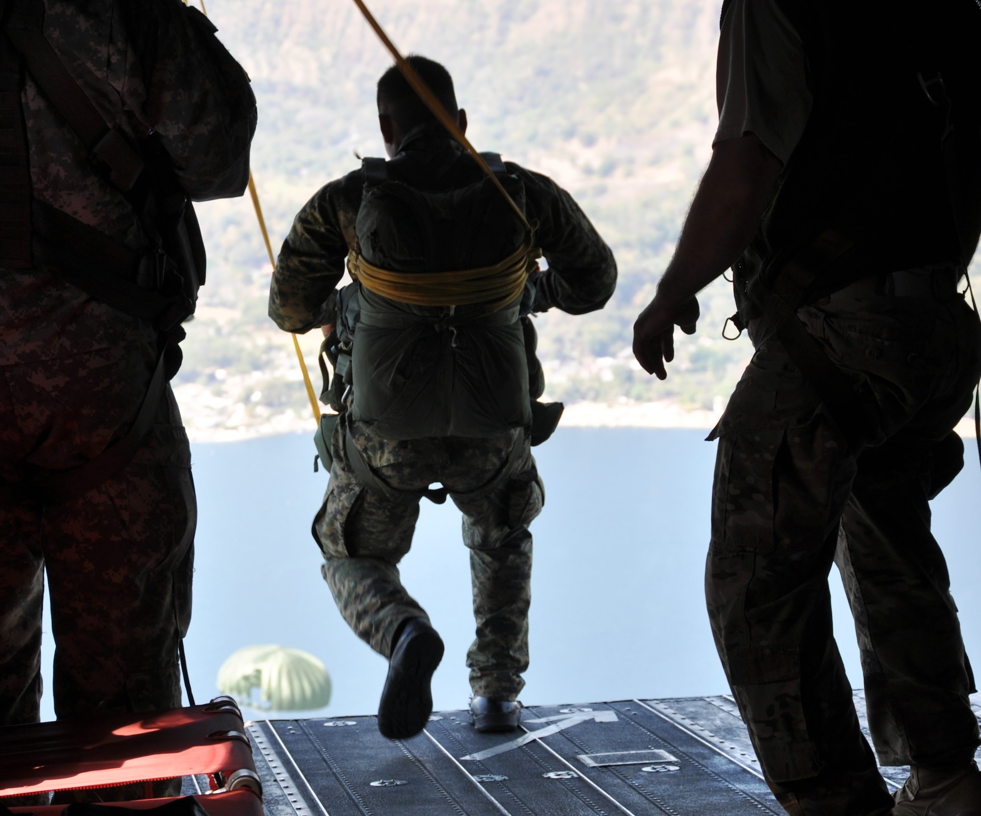 A member of the El Salvadoran military jumps from the ramp of a CH-47 Chinook helicopter during a joint airborne operations training exercise conducted by U.S. Special Forces and El Salvadoran servicemembers over Lake Ilopango, El Salvador, Jan. 21, 2014.  U.S. Special Forces from the 7th Special Forces Group (Airborne) conducted the training exercise alongside members of the El Salvadoran military.  The joint-training, overwater static jump allowed members from both nations to maintain currency while strengthening the relationship between the U.S. and El Salvadoran forces.  Joint Task Force-Bravo’s 1-228th Aviation Regiment provided aerial support for the exercise, flying each chalk of jumpers from the Ilopango International Airport to the drop zone over Lake Ilopango.  (U.S. Air Force photo by Capt. Zach Anderson)