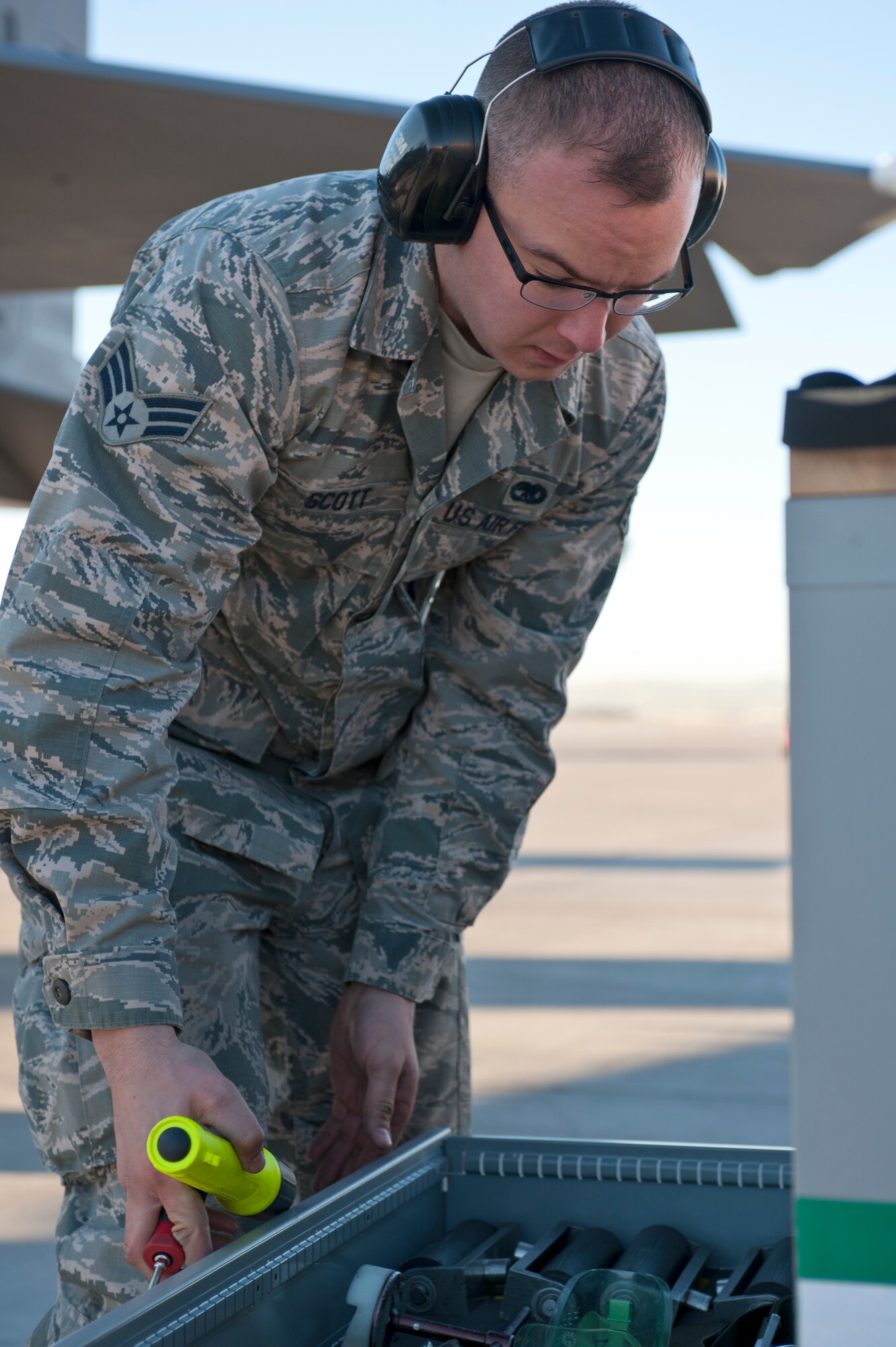 Senior Airman Joshua Scott, 757th Aircraft Maintenance Squadron Strike Aircraft Maintenance Unit load crew member, puts away tools during the annual load crew competition on the flightline Jan. 17, 2014, at Nellis Air Force Base, Nev. The Airmen are graded on a written test, dress and appearance, their composite tool kit and the load. (U.S. Air Force photo by Senior Airman Matthew Lancaster)
