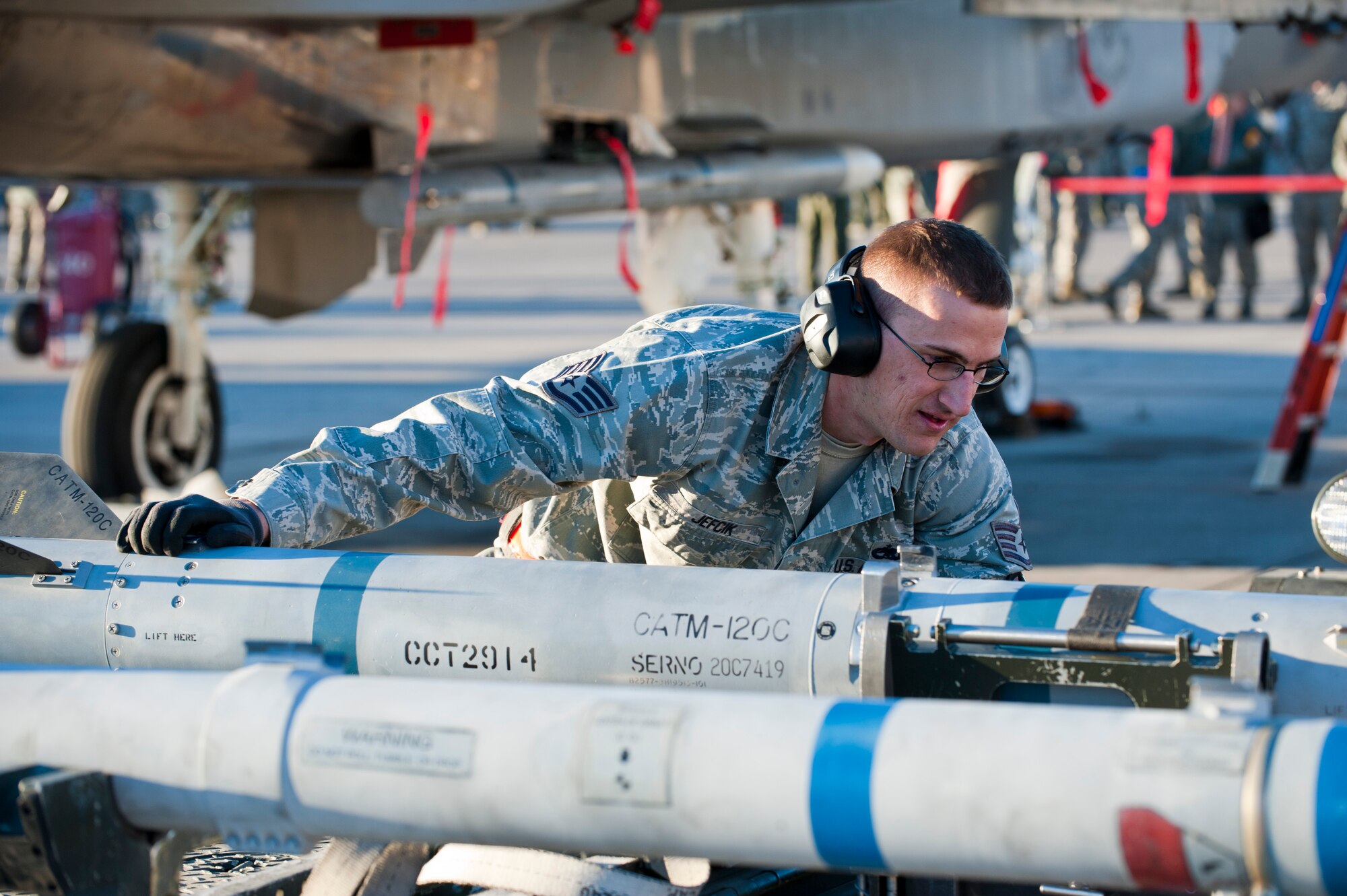 U.S. Air Force Staff Sgt. Ronald Jefcik, 757th Aircraft Maintenance Squadron Eagle Aircraft Maintenance Unit weapons load crew chief, prepares inert munitions for loading during the annual load crew competition on the flightline Jan. 17, 2014, at Nellis Air Force Base, Nev. Seven load crews competed against one another to determine which crew could correctly load weapons on to their respective aircraft the fastest. (U.S. Air Force photo by Airman 1st Class Thomas Spangler)