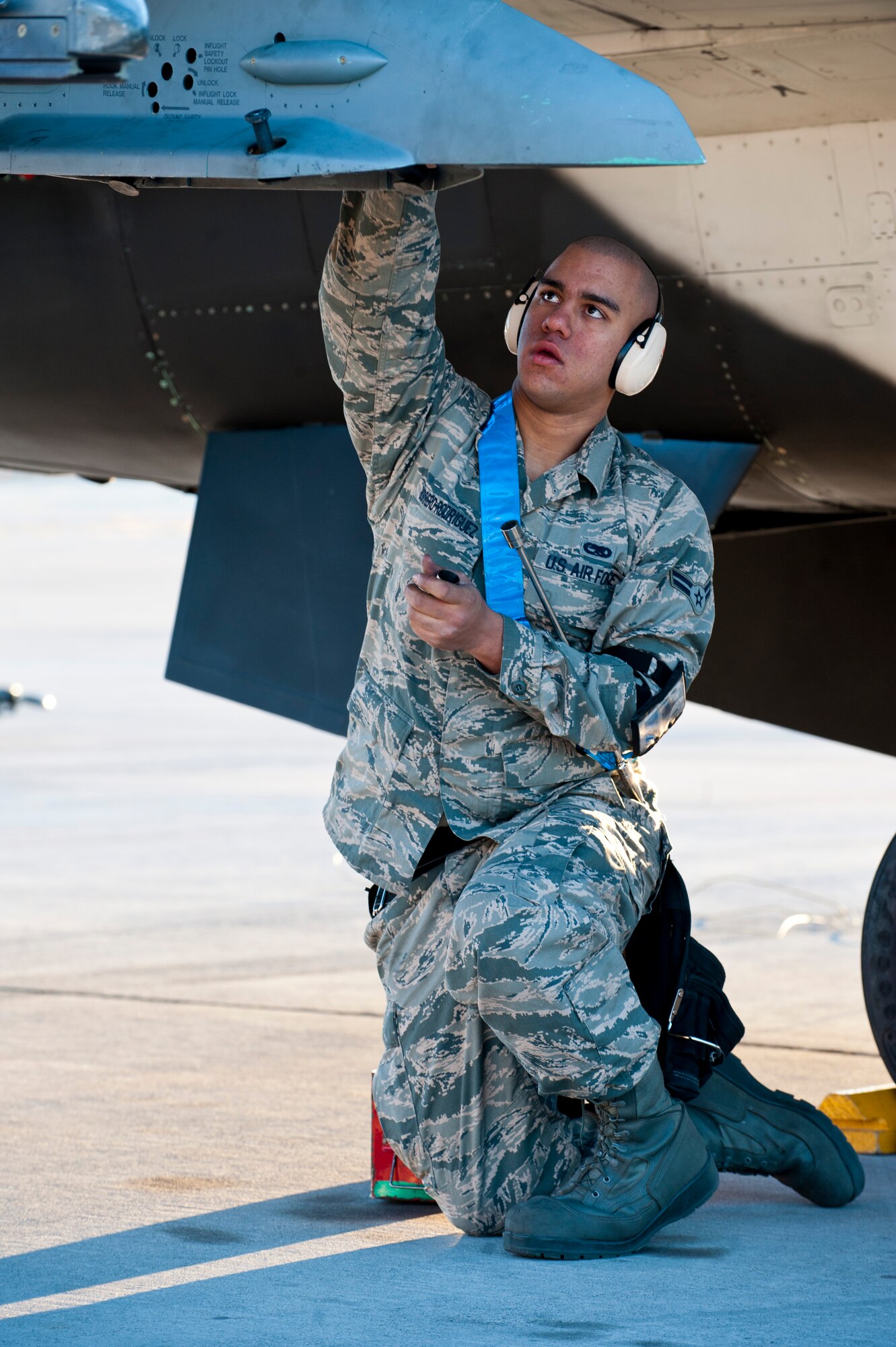 U.S. Air Force Airman 1st Class Johnathan Borrero-Rodriguez, 57th Aircraft Maintenance Squadron Viper Aircraft Maintenance Unit weapons load crew member, prepares an aircraft for weapons loading during the annual load crew competition on the flightline Jan. 17, 2014, at Nellis Air Force Base, Nev. Load crew competitions are held four times a year in addition to an annual competition to determine the best load crew of the year. The winning team will be announced at the Maintenance Professional of the Year Banquet. (U.S. Air Force photo by Airman 1st Class Thomas Spangler)