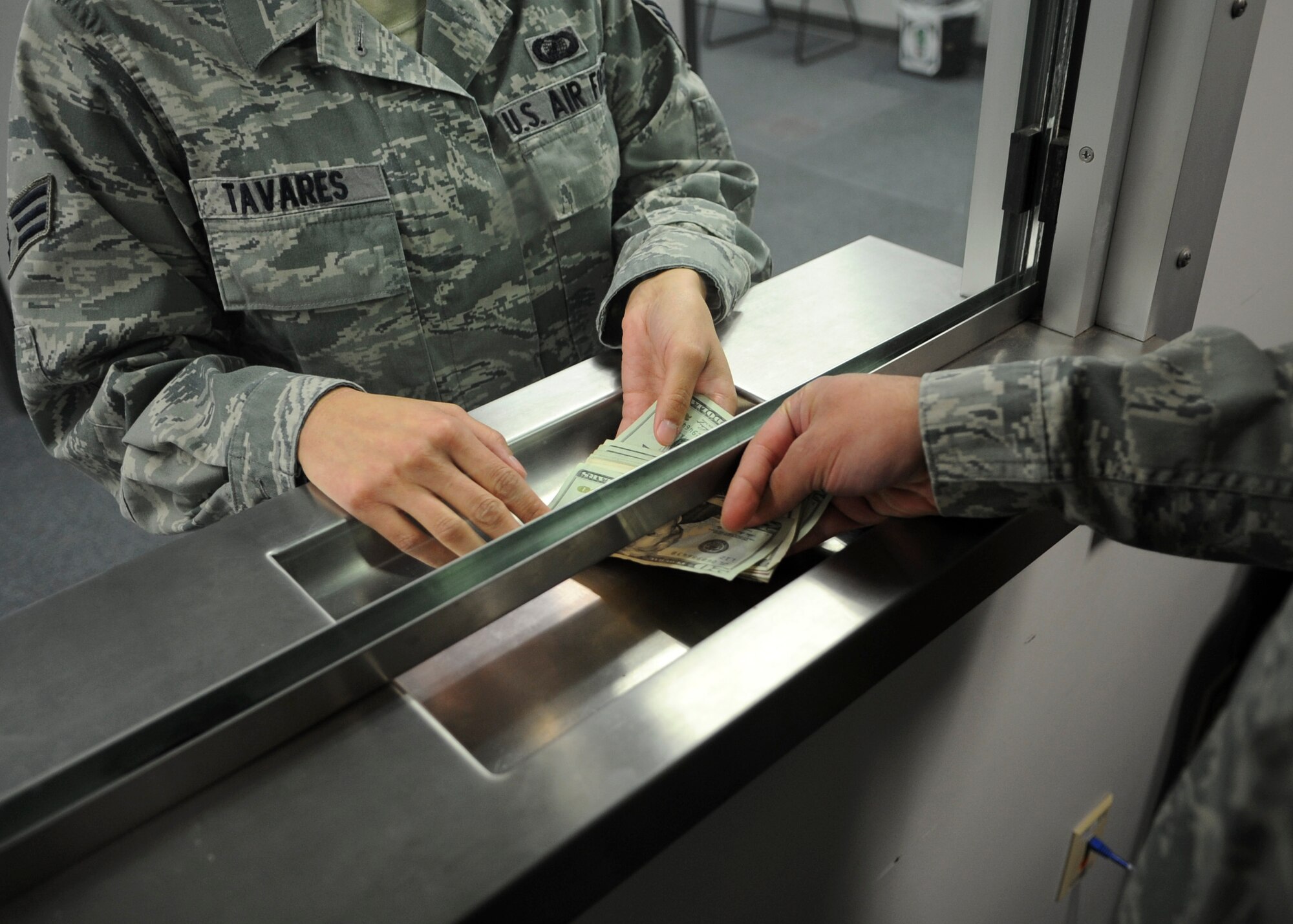 Senior Airman Tiffany Tavares, a customer, receives money from Airman 1st Class Stanley Wilson, 436th Comptroller Squadron financial technician cashier, Jan. 22, 2014, at Dover Air Force Base, Del. The financial services flight won the Financial Services Office of the Year for the second consecutive year. (U.S. Air Force photo/Airman 1st Class Zachary Cacicia)