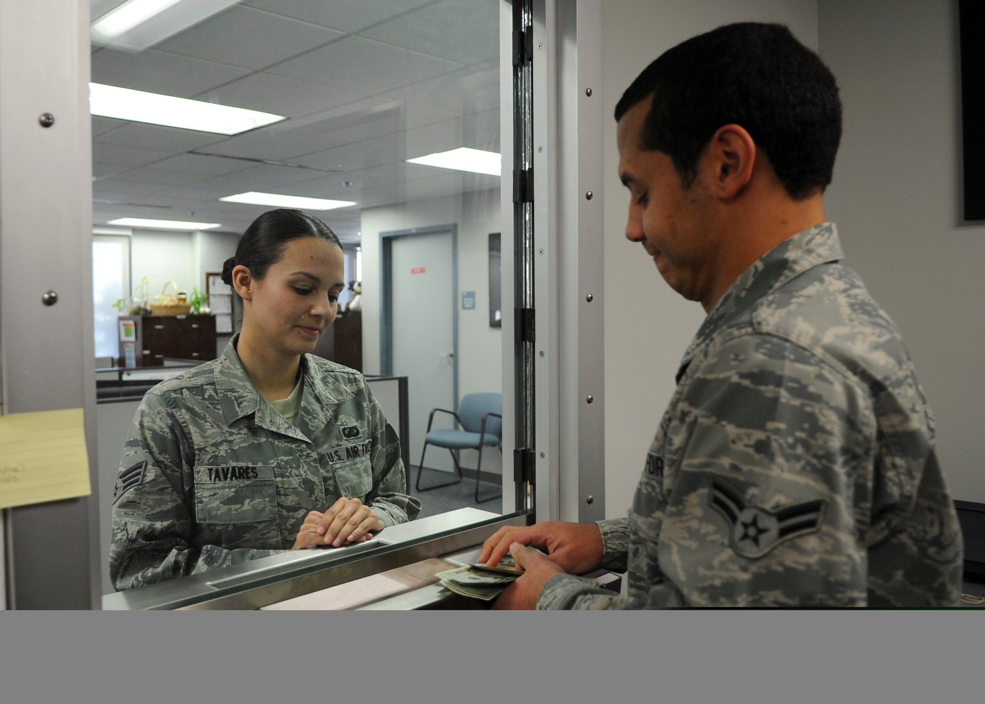 Senior Airman Tiffany Tavares, a customer, waits as Airman 1st Class Stanley Wilson, 436th Comptroller Squadron financial technician cashier, counts her money Jan. 22, 2014, at Dover Air Force Base, Del. The 436th CPTS won the Maj. Gen. Alfred K. Flowers Financial Management Comptroller Organization of the Year for 2013 and the financial services flight was recognized as the Financial Services Office of the Year for the second consecutive year. (U.S. Air Force photo/Airman 1st Class Zachary Cacicia)