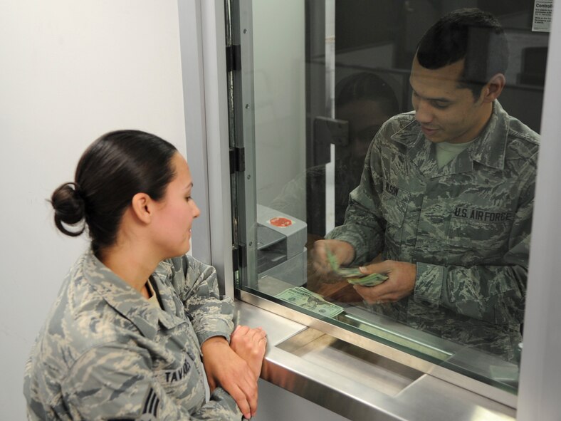 Airman 1st Class Stanley Wilson, 436th Comptroller Squadron financial technician cashier, counts out money to customer, Senior Airman Tiffany Tavares, Jan. 22, 2014, at Dover Air Force Base, Del. The 436th CPTS won two Air Mobility Command awards for 2013. (U.S. Air Force photo/Airman 1st Class Zachary Cacicia)