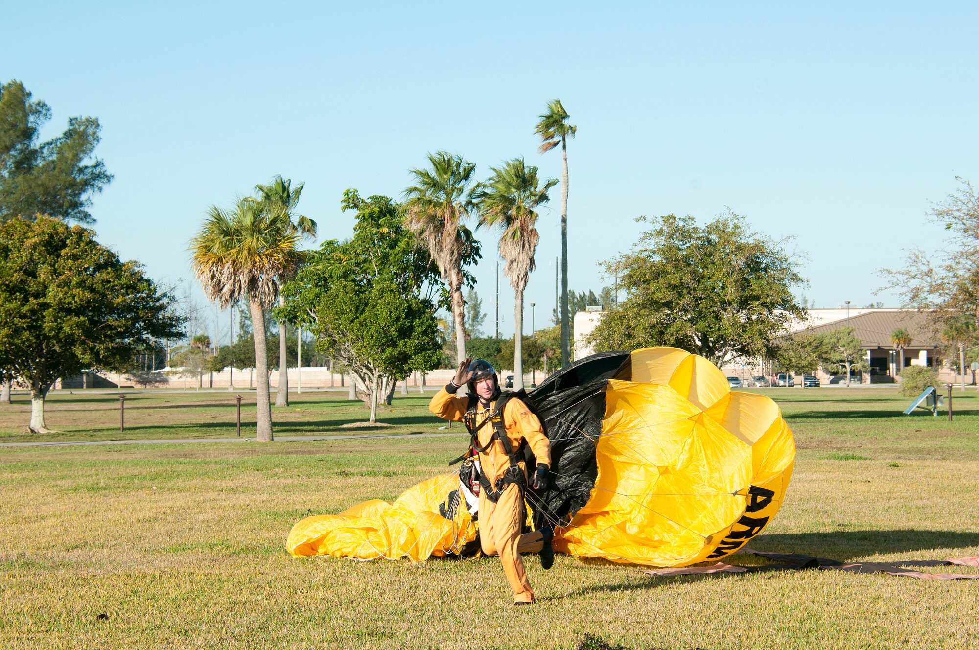 A member of the U.S. Army parachute team, The Golden Knights, waves after landing at Homestead Air Reserve Base during their first day of training on Jan. 22.  The “Knights” are back at Homestead ARB for a fifth straight year conducting winter training.  Residents that live around the base will see the team's signature yellow and black parachutes until mid-March. (U.S. Air Force photo/Tim Norton)
