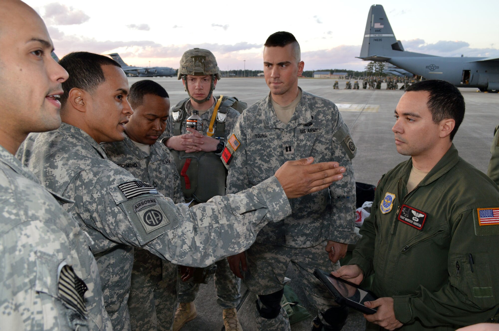 Army paratroopers from the 82nd Airborne Division talk with Air Force Tech. Sgt. Marcos Garcia, a C-130 Hercules aircraft loadmaster from the 41st Airlift Squadron, Little Rock AFB, Ark., before loading onto C-130 aircraft during joint exercise Global Response Expeditor on Jan. 15, 2014, at Pope Army Airfield, Fort Bragg, N.C. The purpose of this exercise was to prepare United States Transportation Command units, Air Mobility Command forces and elements of the XVIII Airborne Corps to respond as part of the Global Response Force and to conduct Joint Forcible Entry operations. This exercise executed Joint Forcible Entry operations in support of a combined Joint Task Force utilizing drop zones at the Joint Readiness Training Center, Fort Polk, La. Air mobility aircraft and crews airdropped approximately 1,124 paratroopers and offloaded more than 120 short tons of cargo. (U.S. Air Force photo/Marvin Krause)

