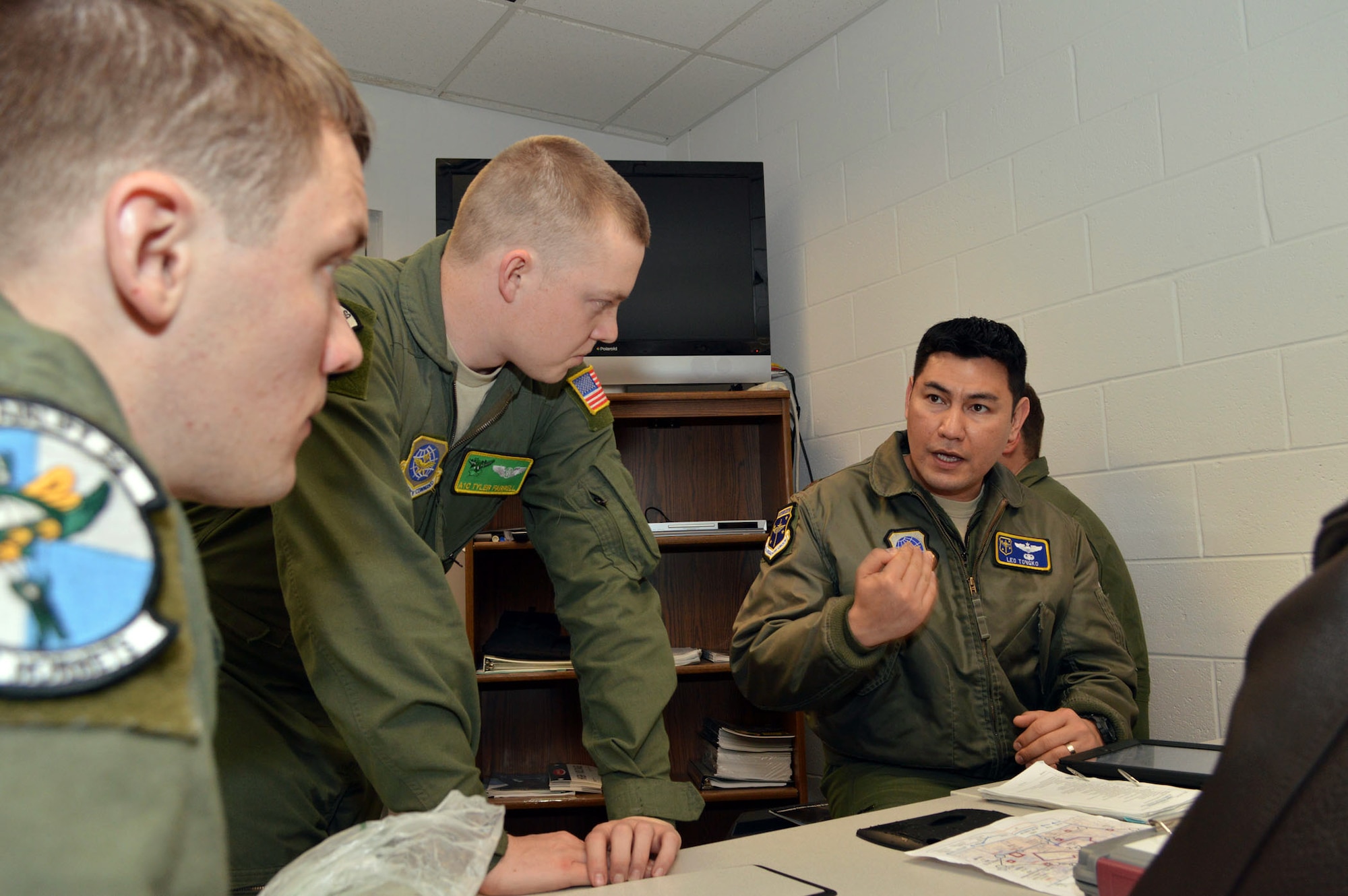 Air Force Maj. Leo Tongko, a C-130J Hercules pilot from the 61st Airlift Squadron, Little Rock AFB, Ark., conducts a mission briefing with his aircrew, Senior Airman Brandon Rader and Airman 1st Class Tyler Farrell, loadmasters from the 61st Airlift Squadron, during joint exercise Global Response Expeditor on Jan. 15, 2014, at Pope Army Airfield, Fort Bragg, N.C. The purpose of this exercise was to prepare United States Transportation Command units, Air Mobility Command forces and elements of the XVIII Airborne Corps to respond as part of the Global Response Force and to conduct Joint Forcible Entry operations. This exercise executed Joint Forcible Entry operations in support of a combined Joint Task Force utilizing drop zones at the Joint Readiness Training Center, Fort Polk, La. Air mobility aircraft and crews airdropped approximately 1,124 paratroopers and offloaded more than 120 short tons of cargo. (U.S. Air Force photo/Marvin Krause)