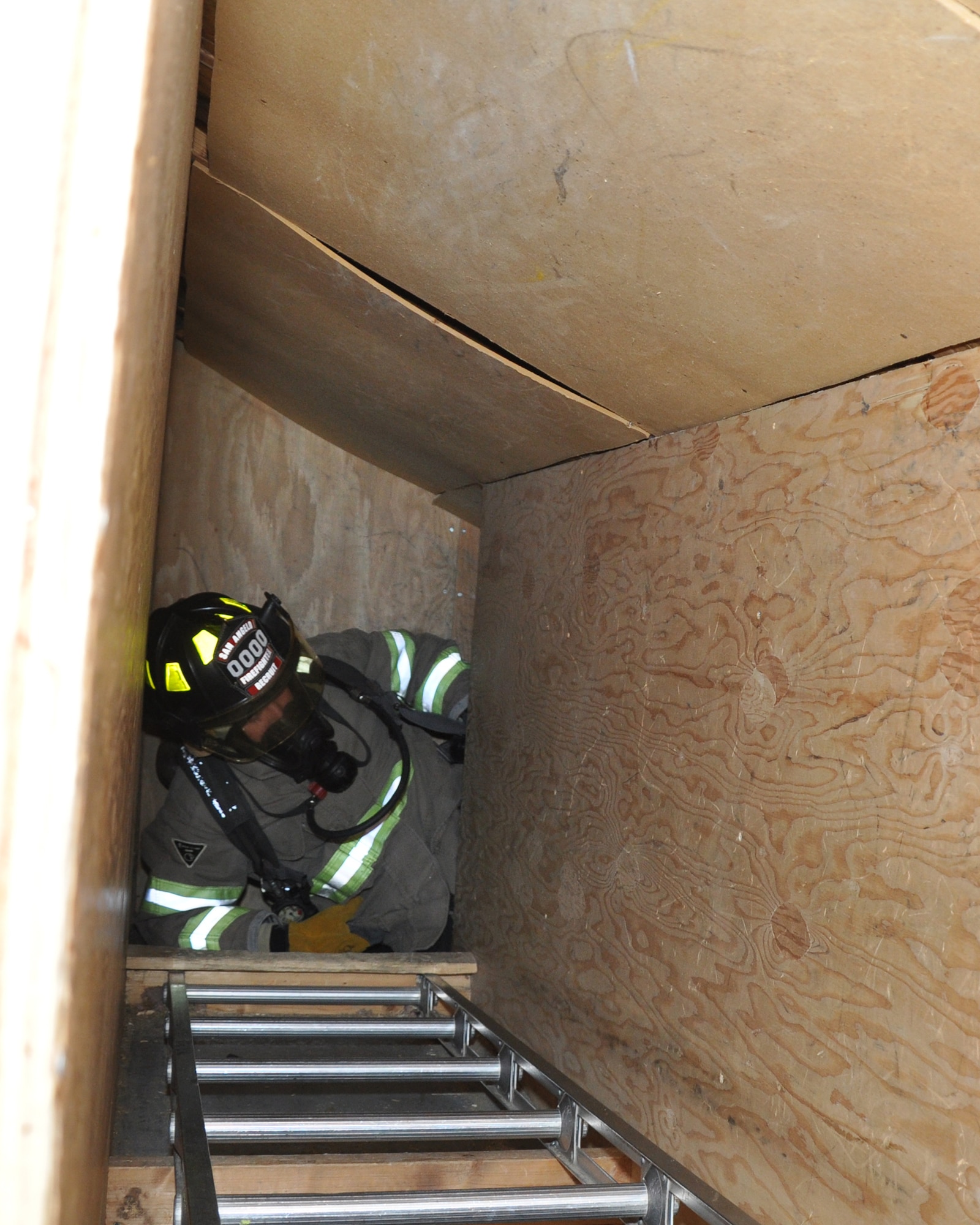 GOODFELLOW AIR FORCE BASE, Texas – A San Angelo Fire Department recruit crawls through the attic confined space simulator at the Louis F. Garland DoD Fire Academy Jan. 17. Goodfellow Air Force Base and the SAFD expect all its trainees to transverse the obstacles in the dark to monitor air usage and ensure they know how to identify hazards. (U.S. Air Force photo/ Senior Airman Joshua Edwards)