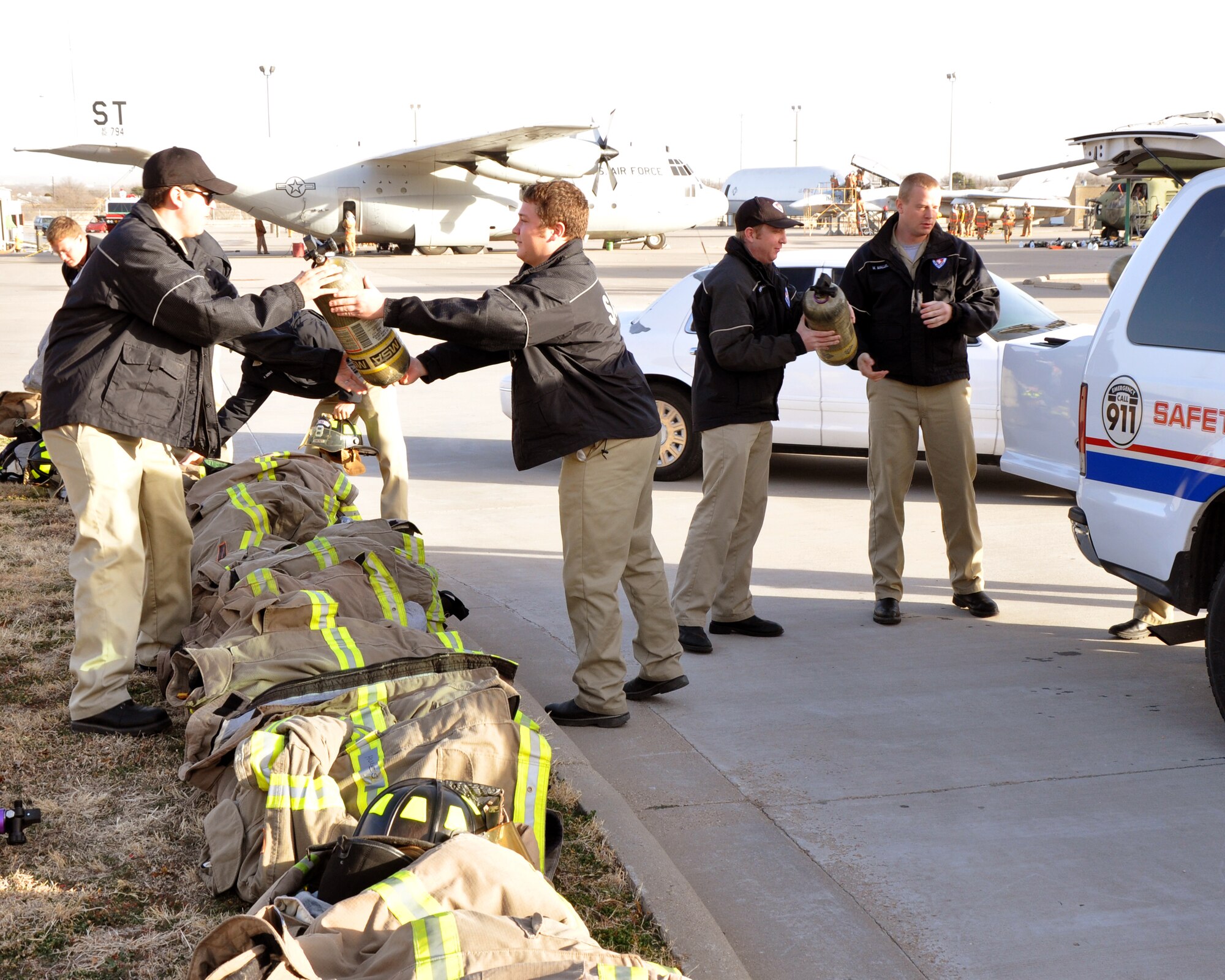 GOODFELLOW AIR FORCE BASE, Texas – San Angelo Fire Department recruits unpack air canisters from a  SAFD safety vehicles at the Louis F. Garland DoD Fire Academy Jan. 17. The air canisters helped familiarize recruits with their equipment and become efficient at controlling their breathing while navigating a confined space trainer.  (U.S. Air Force photo/ Senior Airman Joshua Edwards)