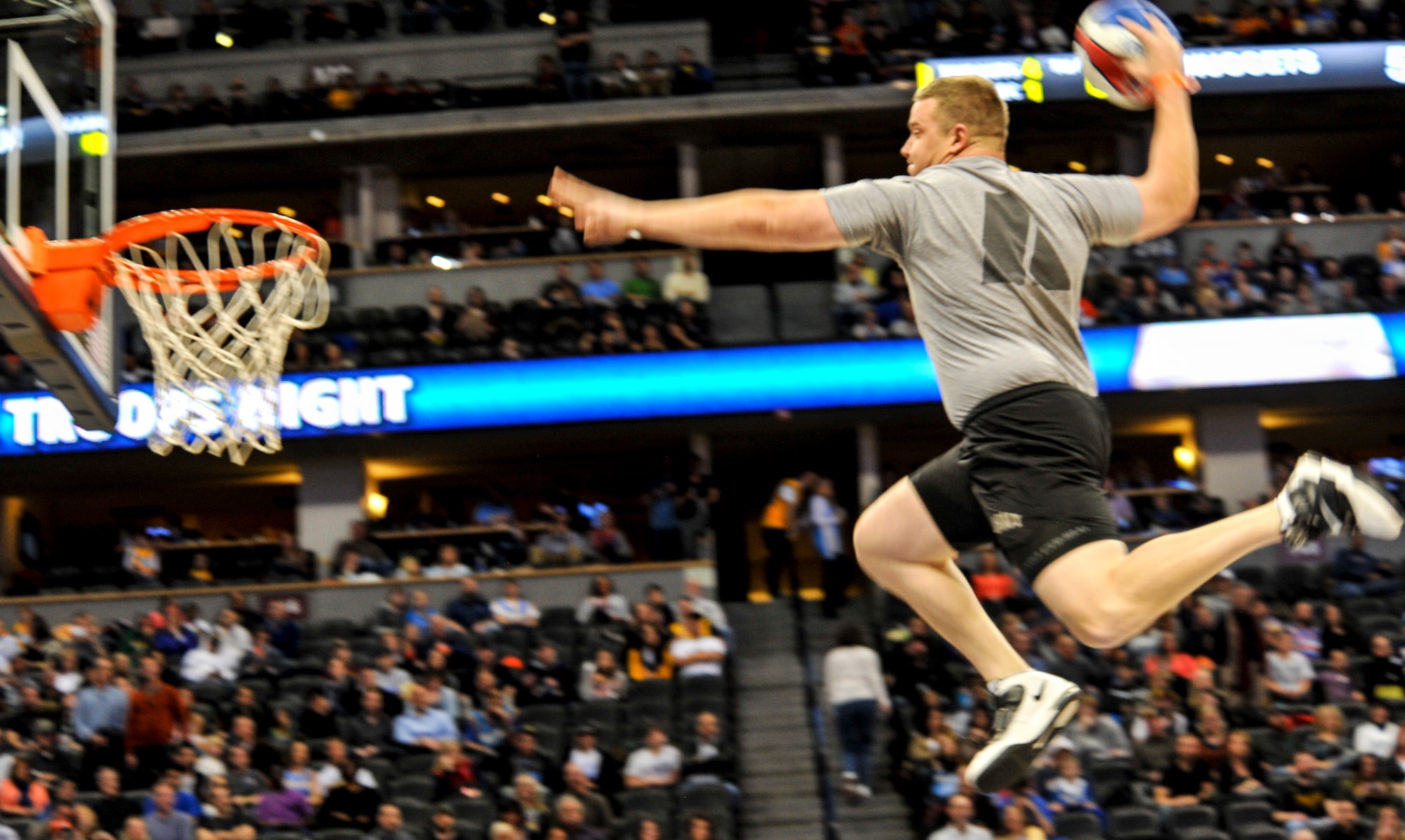 A Soldier lines up a slam dunk after being launched from a trampoline at the Denver Nuggets vs. Cleveland Cavaliers game Jan. 17, 2014, at the Pepsi Center in Denver. The Nuggets showed their appreciation for service members by honoring all branches of military service at the game. (U.S. Air Force photo by Airman 1st Class Samantha Saulsbury/Released)