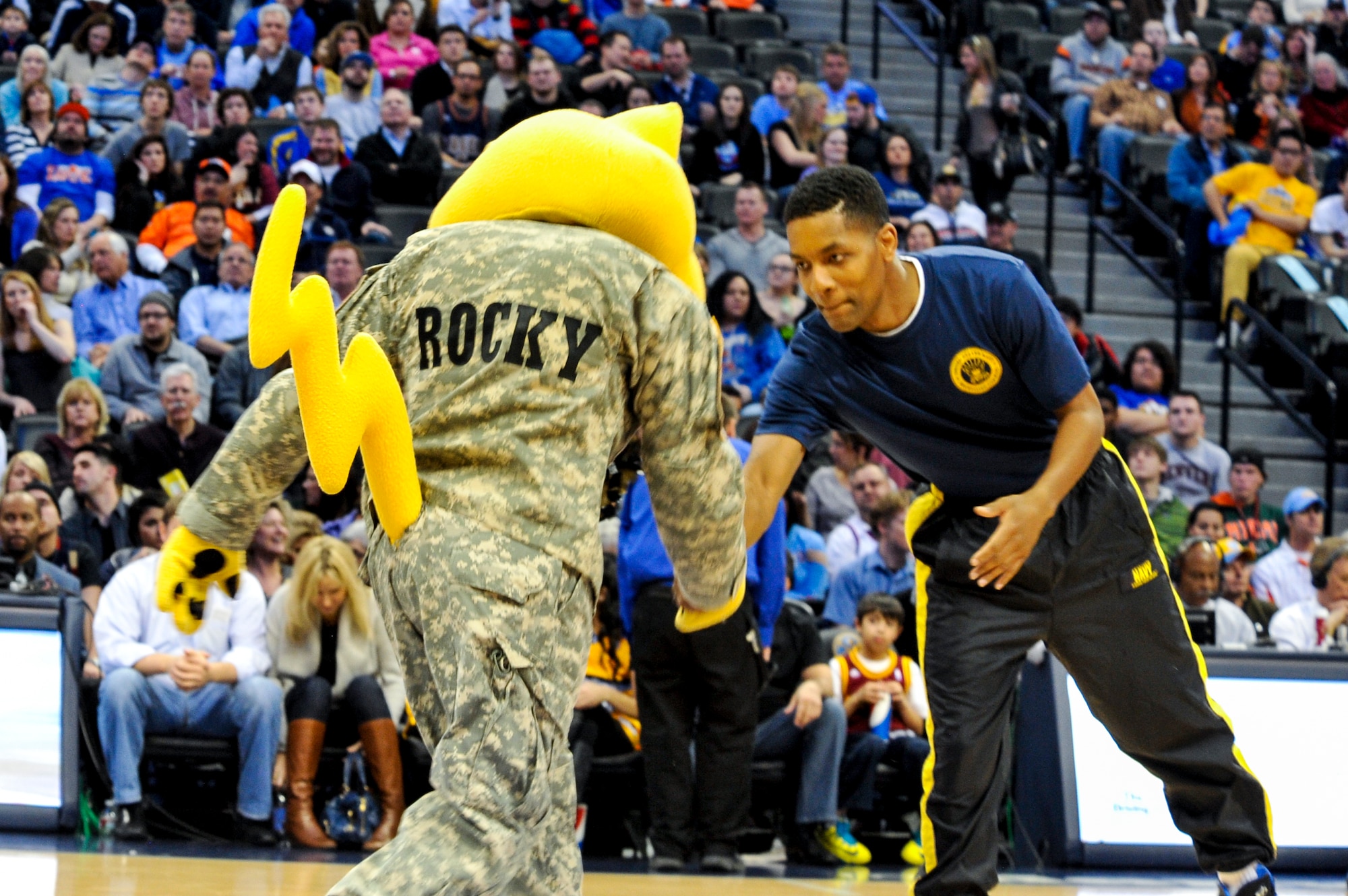 Rocky, Denver Nuggets mascot, high fives a Sailor before the push-up challenge at the Denver Nuggets vs. Cleveland Cavaliers game Jan. 17, 2014, at the Pepsi Center in Denver. The Nuggets showed their appreciation for the service members by honoring all branches of military service at the game. (U.S. Air Force photo by Airman 1st Class Samantha Saulsbury/Released