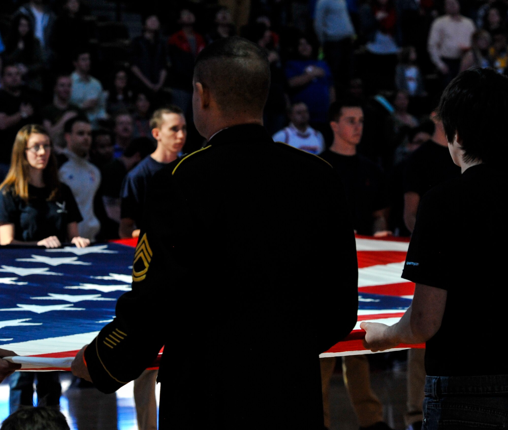 A Soldier spreads open the U.S. flag with future military members during the national anthem at the Denver Nuggets vs. Cleveland Cavaliers game Jan. 17, 2014, at the Pepsi Center in Denver. The Nuggets showed their appreciation for service members by honoring all branches of military service at the game. (U.S. Air Force photo by Airman 1st Class Samantha Saulsbury/Released)