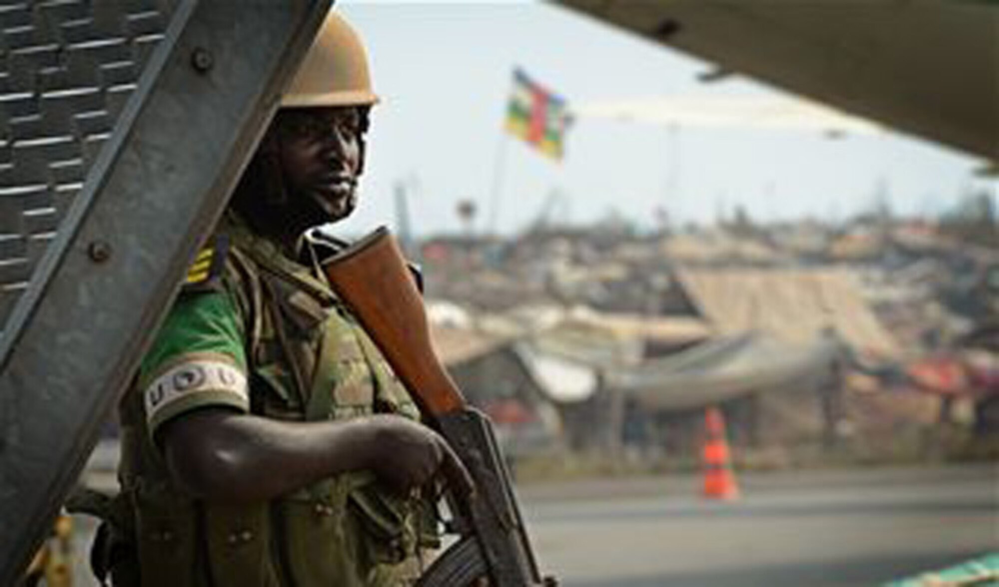 A Rwandan soldier stands guard at an airfield in the Central African Republic with a refugee camp full of displaced citizens behind him Jan. 19, 2014. U.S. forces will transport a total number of 850 Rwandan soldiers and more than 1,000 tons of equipment into the Central African Republic to aid French and African Union operations against militants during this three week-long operation. (U.S. Air Force photo/ Staff Sgt. Ryan Crane)