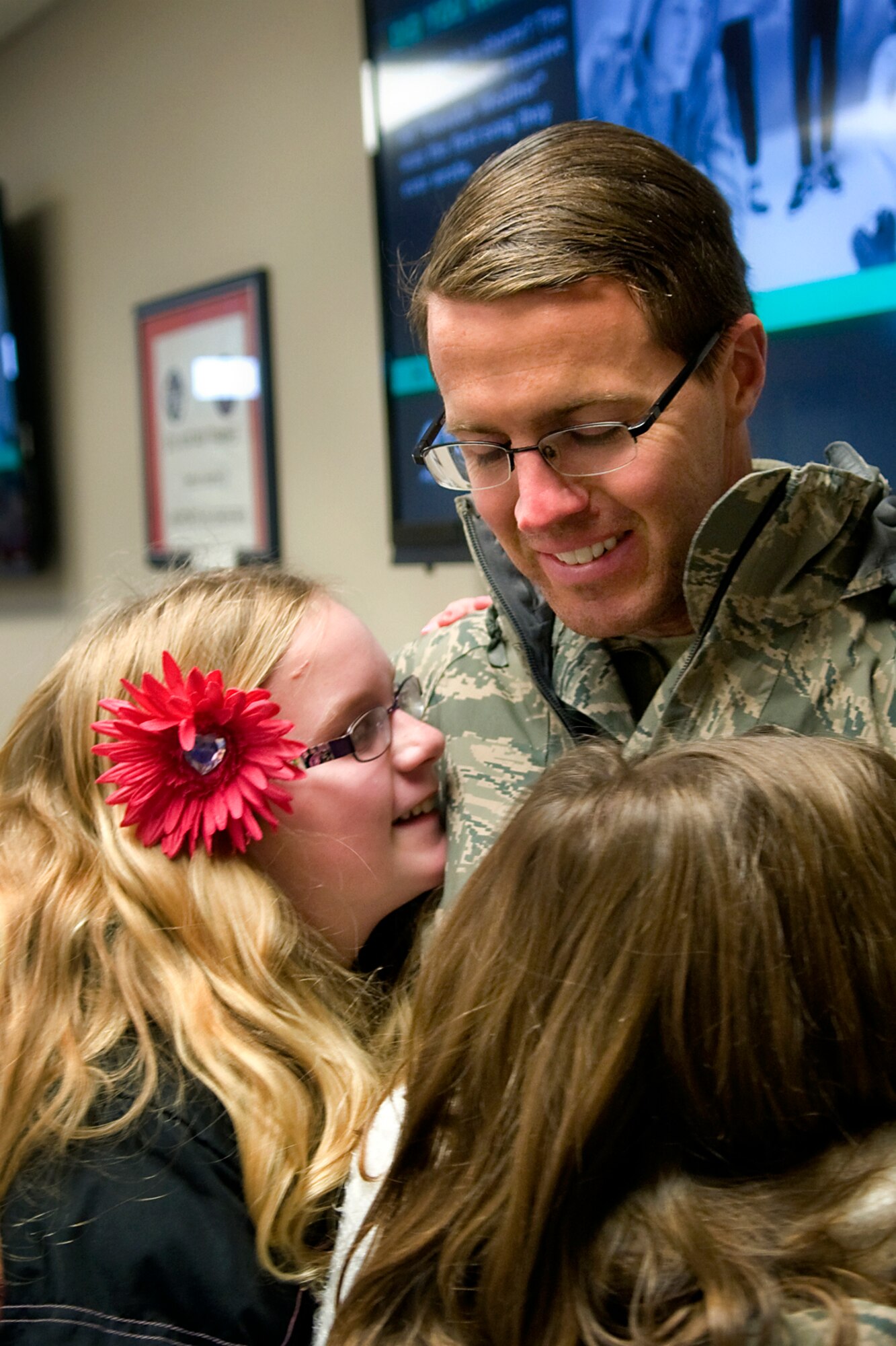 Tech. Sgt. Brian Baumfalk, 434th Maintenance Squadron crew chief, hugs his daughters Bridget, left and Elisabeth, right, after returning from a deployment at Grissom Air Reserve Base, Ind., Jan. 20, 2014. Twenty 434th Air Refueling Wing Airmen returned to Grissom, completing a deployment cycle to Al Udeid Air Base, Qatar, that began in May 2013 that included 138 Airmen deploying during that time. (U.S. Air Force photo/Tech. Sgt. Mark R. W. Orders-Woempner) 
