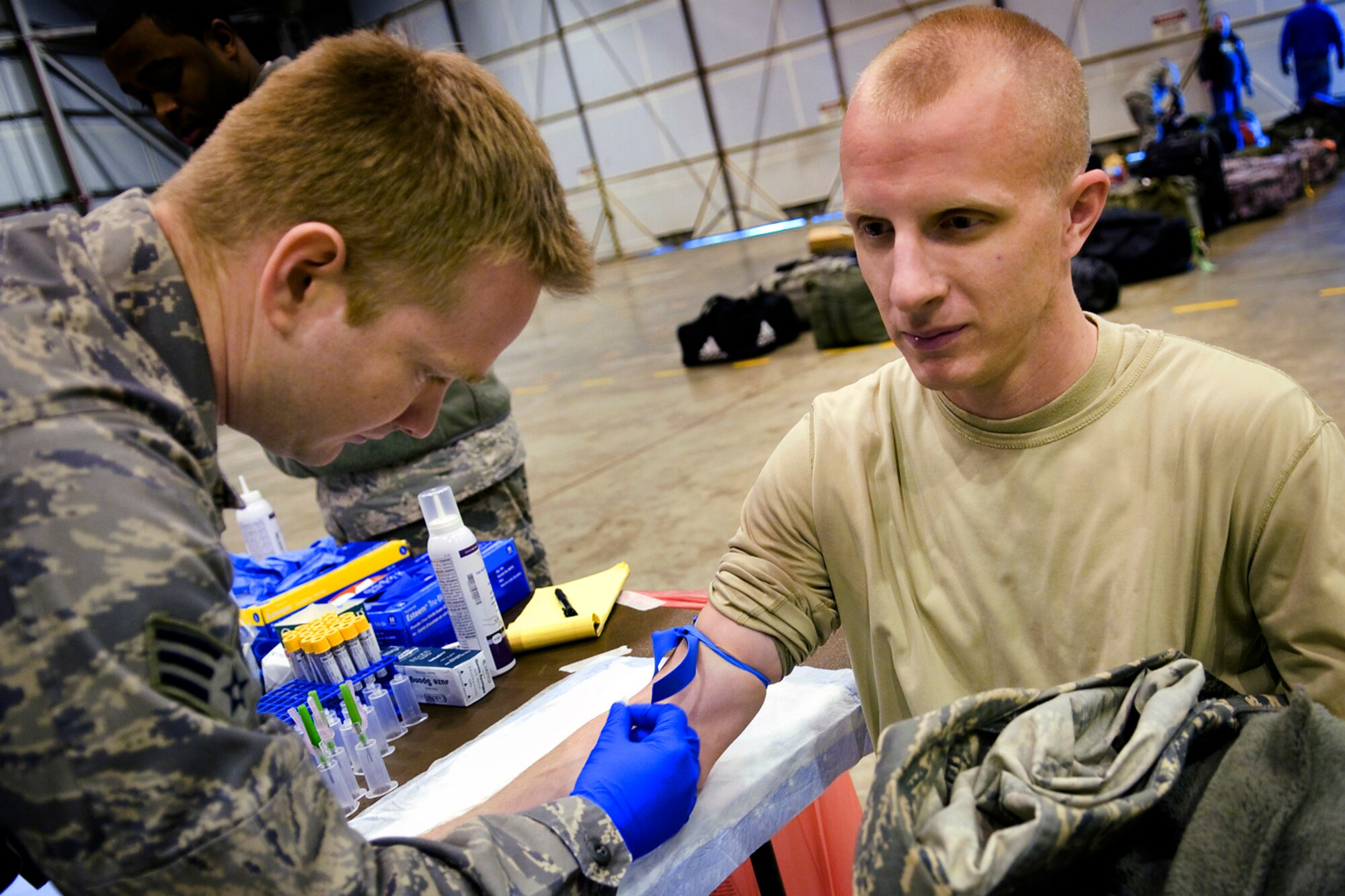 Senior Airman Cameron Harney, 434th Aerospace Medicine Squadron biomedical equipment maintenance specialist, left, collects a blood sample from Senior Airman Chad James, 434th Maintenance Squadron aerospace ground equipment specialist, after James returned from a deployment at Grissom Air Reserve Base, Ind., Jan. 20, 2014. Deployers are required to have their blood taken before and after a deployment to ensure their health and safety (U.S. Air Force photo/Tech. Sgt. Mark R. W. Orders-Woempner) 
