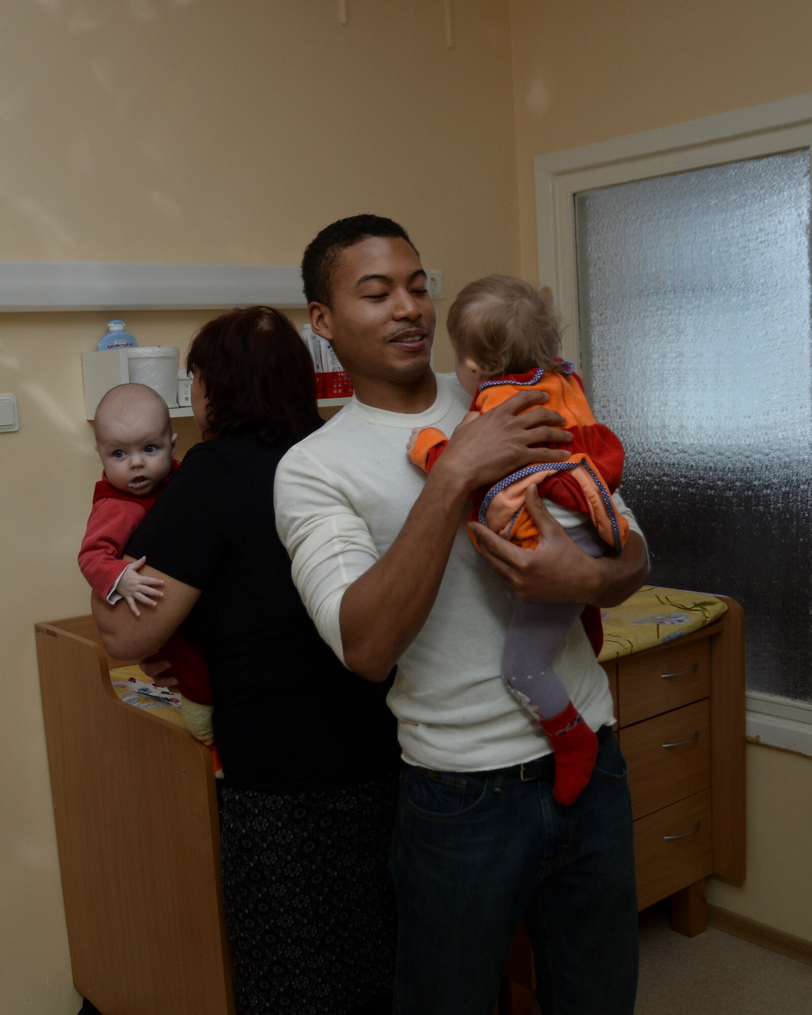 Staff Sgt. Christopher Lyn, aircraft arresting systems journeyman, 435th Construction and Training Squadron, Ramstein Air Base, holds a baby at the Šiauliai City Baby’s Orphanage in Lithuania, Jan. 9, 2014. Airmen volunteered during the NATO Baltic Air Policing mission to give back to the host community. (U.S. Air Force photo by Airman 1st Class Nigel Sandridge/Released)