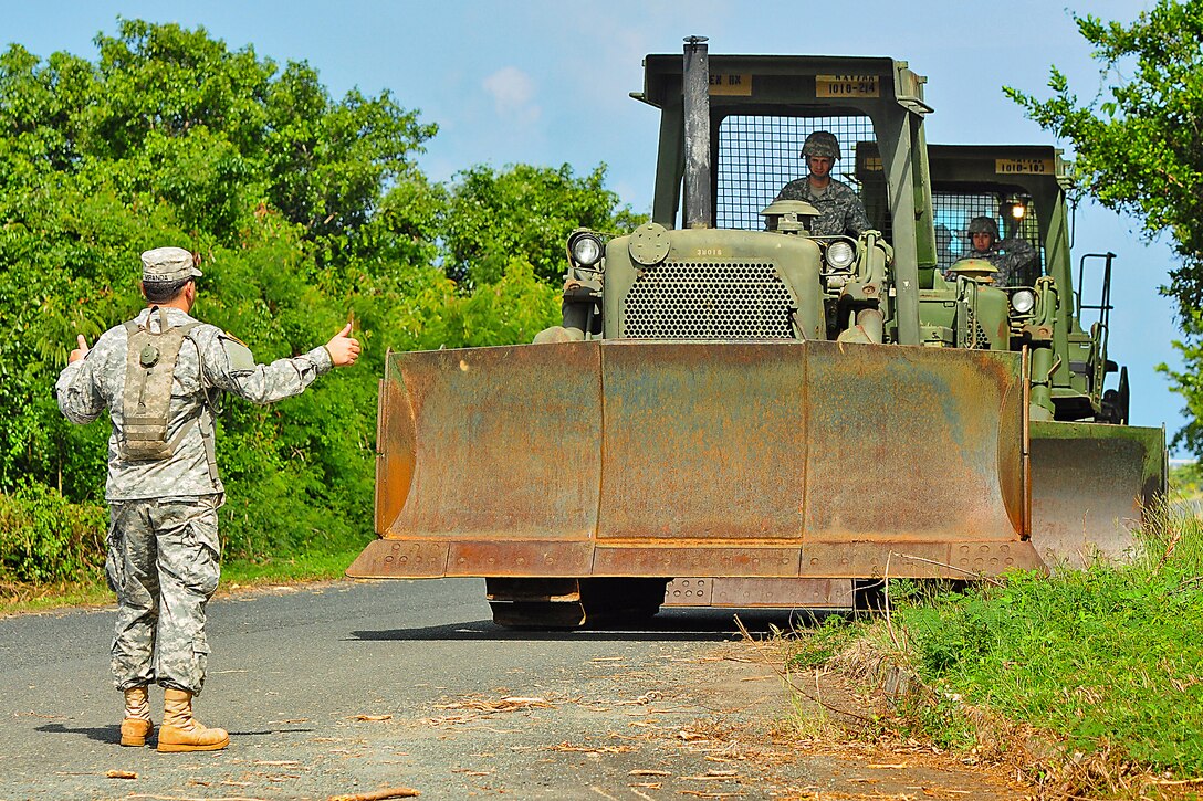 Army Sgt. Luis Miranda leads equipment operators from the ground en route to Mosquito Bay in Vieques, Puerto Rico, Jan. 20, 2014. Miranda is assigned to the Puerto Rico Army National Guard's 1010th Engineer Company, 130th Engineer Battalion.