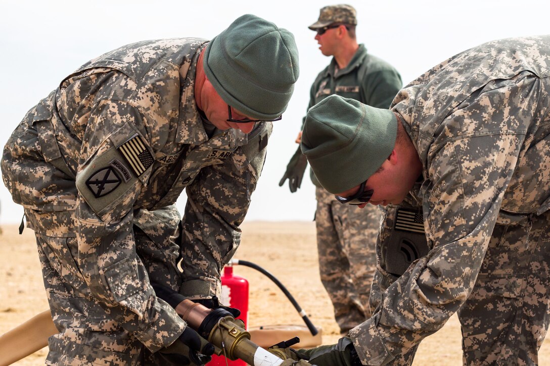 U.S. soldiers set up fueling hoses for AH-64 Apache helicopters during a forward arming and refueling point exercise near Camp Buehring, Kuwait, Jan. 15, 2014.