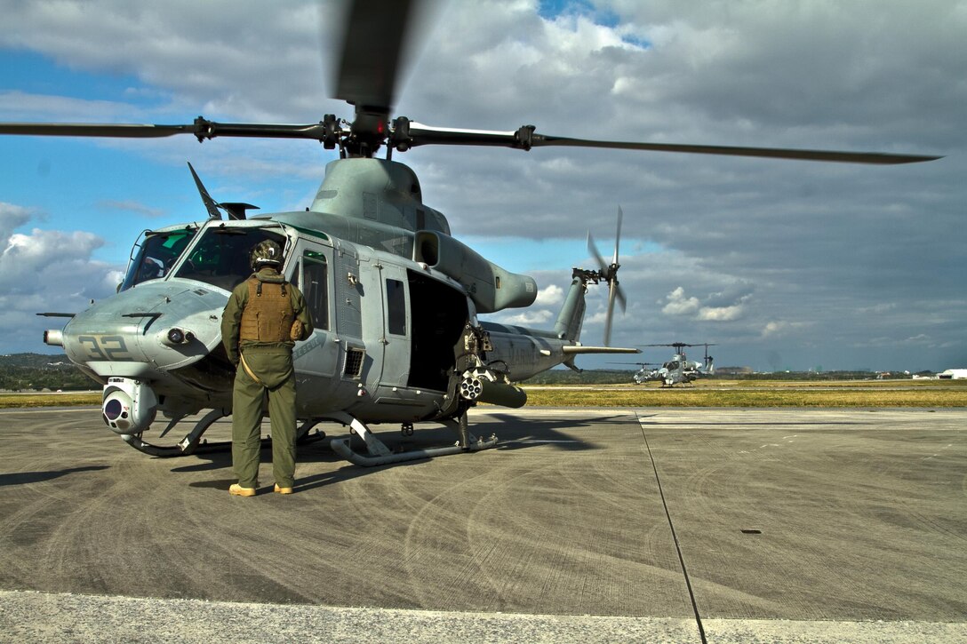 Helicopters prepare to lift off after receiving fuel and ammunition Jan. 16 at Kadena Air Base. The morning flights were simple weapons deployment systems familiarization tests, according to Staff Sgt. Daniel Basan, a crew chief and weapons and tactics instructor. The tests allowed the crew to practice its remedial actions on the door guns and enabled the pilots to prepare for the more advanced flying, which includes assault formations and tactical positioning. The aircraft and Marines are with HMLA-367, currently assigned to VMM-265 (Reinforced), 31st MEU, III MEF. 