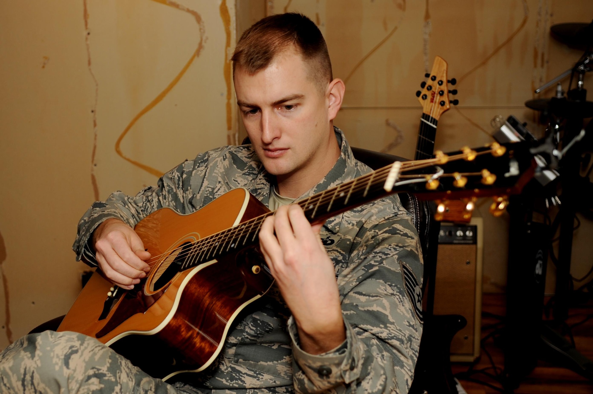 Air Force Reserve Tech. Sgt. Stephen Froeber plays guitar inside his home studio at Hampton, Va., Jan. 10, 2014. He is an aerospace control and warning systems manager with the 710th Comat Operations Squadron at Joint Base Langley-Eustis, Va. Froeber said the skills he learned as an Airman helped him develop a career as a freelance composer. (U.S. Air Force photo by Staff Sgt. Jarad A. Denton)