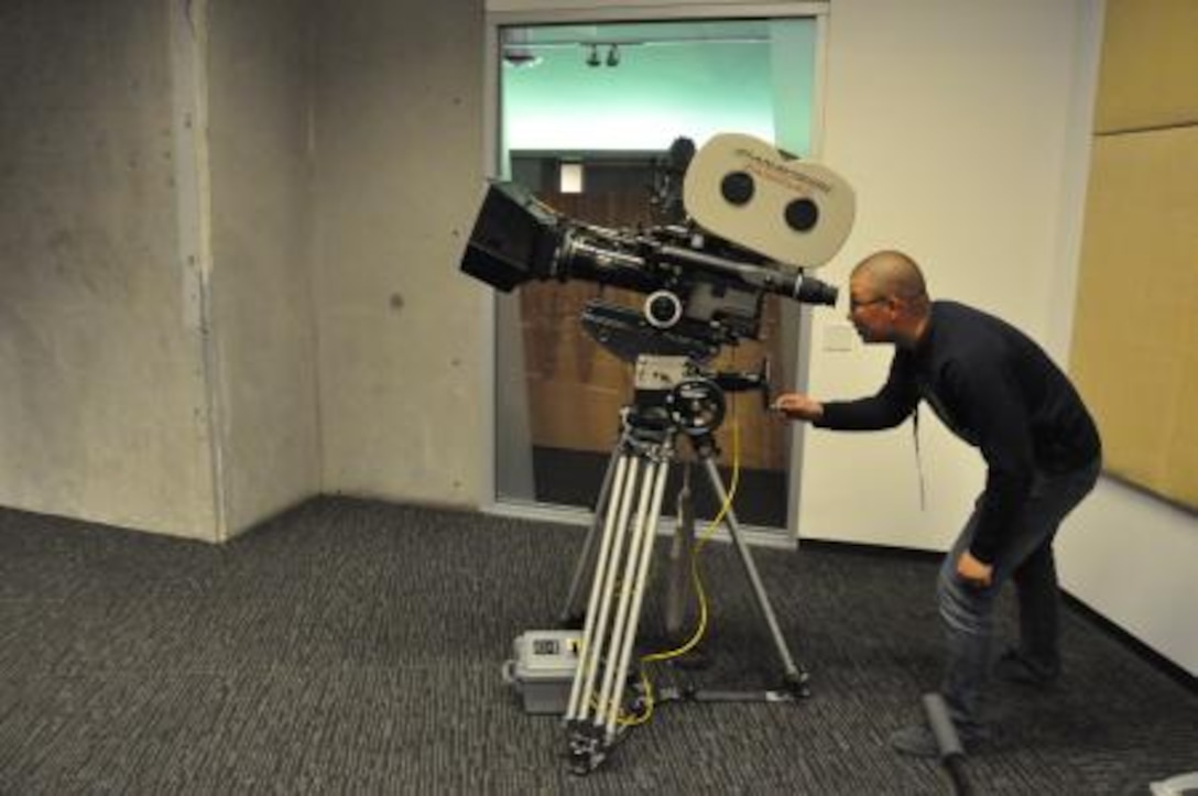 Lance Corporal Brain Ramirez, administrative clerk on Marine Corps Logistics Base Barstow, Calif., looks through a video camera during a Single Marine Program trip to the Los Angeles Film School, April 13, 2013.
