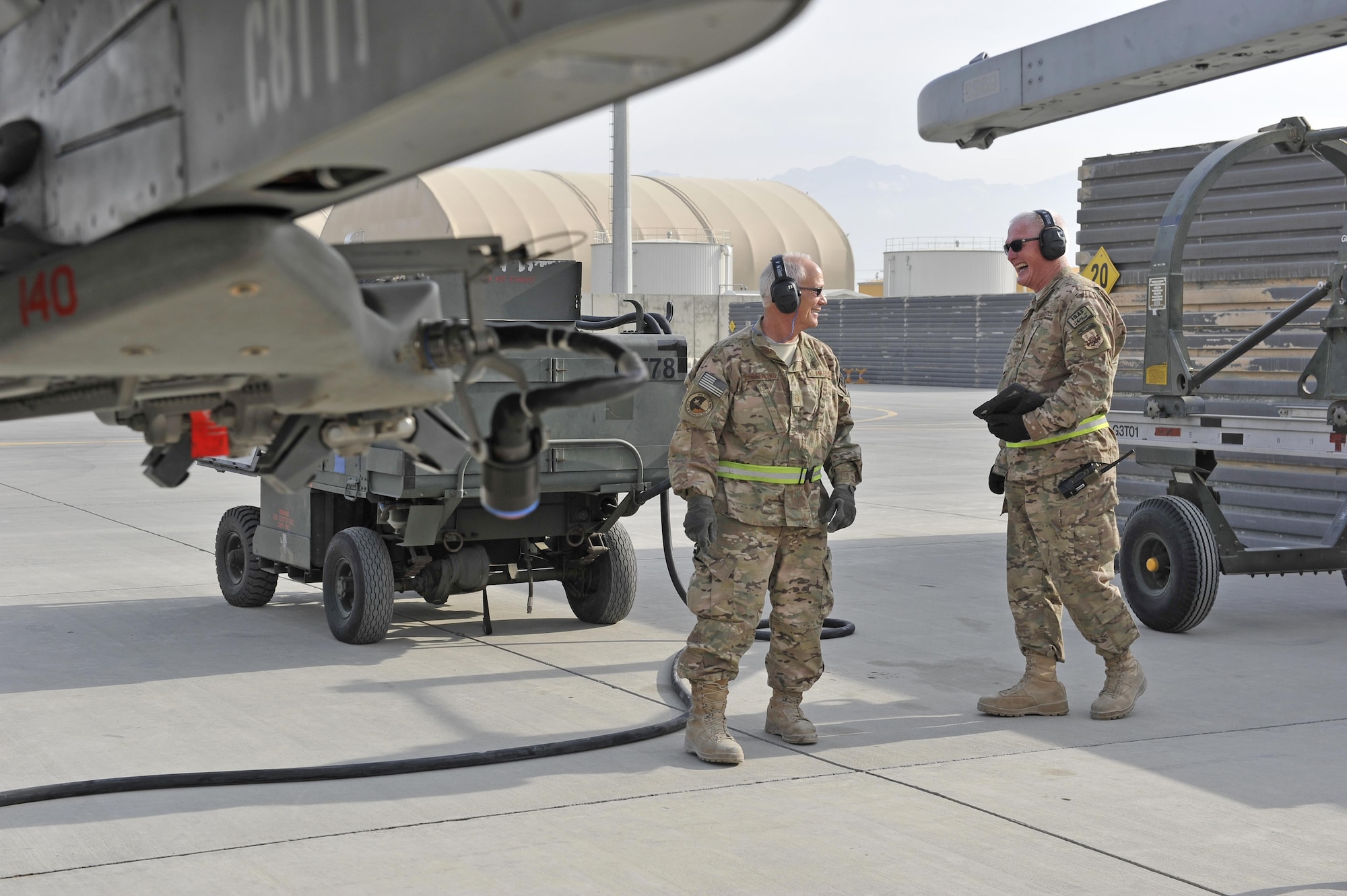 Master Sgt. Doyle Easterling and Senior Master Sgt. Paul Jordan share a light moment together at the end of a sucessful F-16 engine test run at Bagram Airfield, Afghanistan, Jan. 20, 2014. Both are deployed out of Carswell Joint Reserve Base in Fort Worth, Texas to Bagram, and will be retiring this year after a combined 78 years of military service. (U.S. Air Force photo by Senior Master Sgt. Gary J. Rihn)