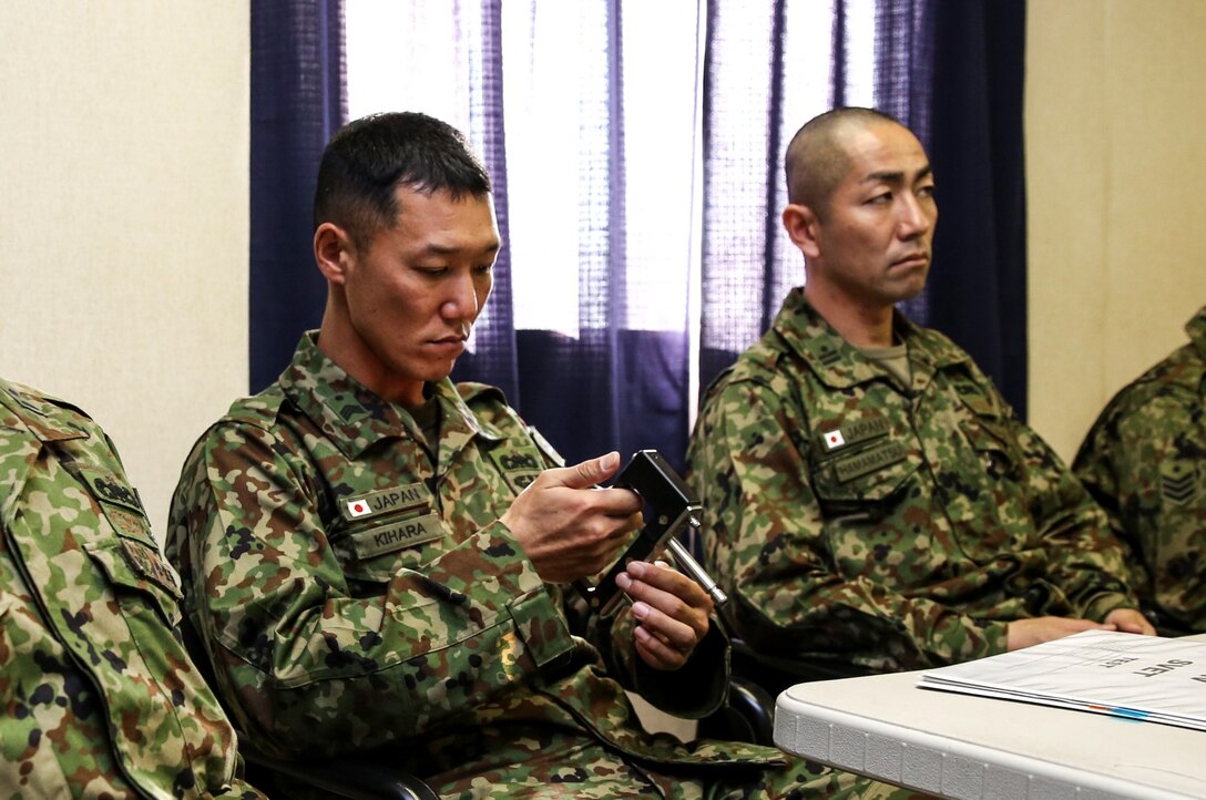 A soldier with Japan Ground Self-Defense Force familiarizes himself with emergency exit handles from an MV-22 Osprey while conducting Underwater Egress training during Exercise Iron Fist 2014 aboard Camp Pendleton, Calif., Jan. 22, 2014. Iron Fist 2014 is an amphibious exercise that brings together Marines and sailors from the 15th Marine Expeditionary Unit, other I Marine Expeditionary Force units, and soldiers from the JGSDF, to promote military interoperability and hone individual and small-unit skills through challenging, complex and realistic training. (U.S. Marine Corps photo by Cpl. Emmanuel Ramos/Released)