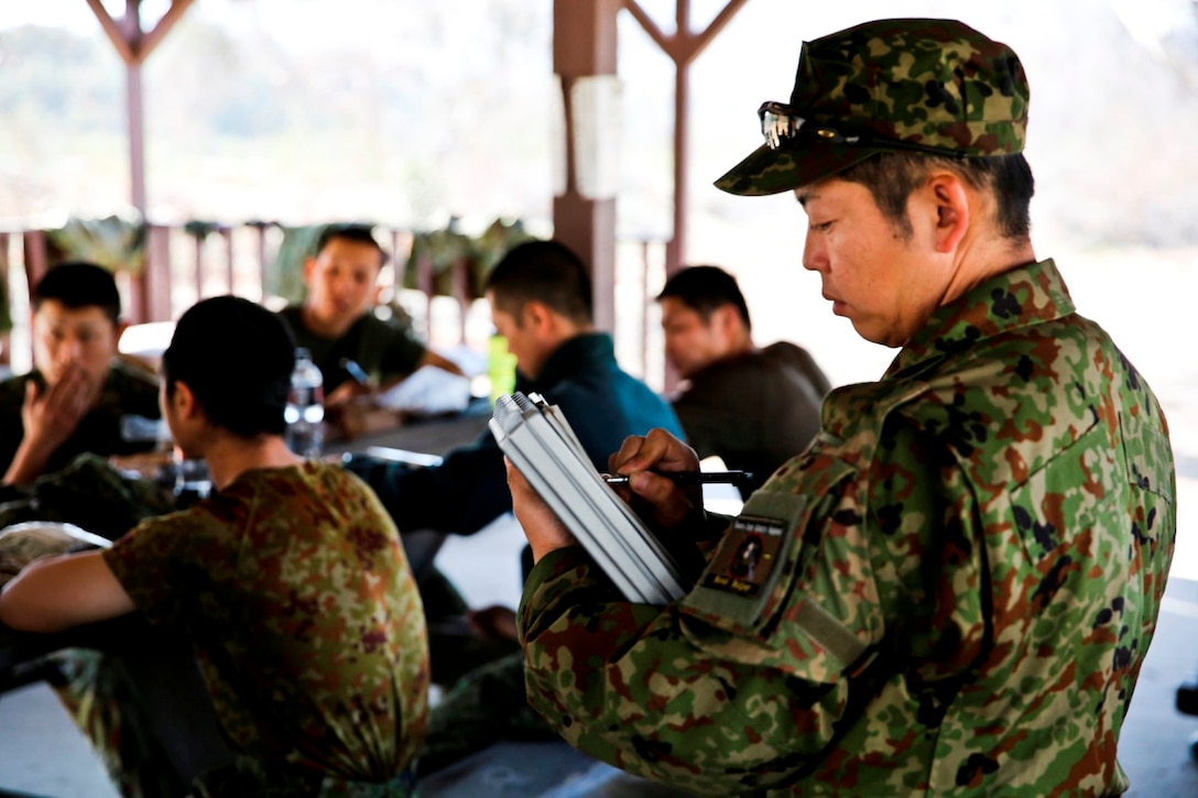 A soldier with the Japan Ground Self Defense Force takes notes during a debrief after conducting land navigation training during Exercise Iron Fist 2014 aboard Camp Pendleton, Calif., Jan. 22, 2014. Iron Fist is an amphibious exercise that brings together Marines and sailors from the 15th Marine Expeditionary Unit, other I Marine Expeditionary Force units, and soldiers from the JGSDF, to promote military interoperability and hone individual and small-unit skills through challenging, complex and realistic training. (U.S. Marine Corps photo by Lance Cpl. Ricardo Hurtado/Released)