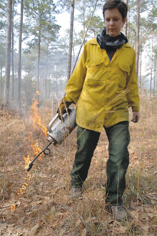 Julie Robbins, natural resource manager, Environmental Branch, Installation and Environment Division, MCLB Albany, sets fire to underbrush during a prescribed burning of base timber, recently.