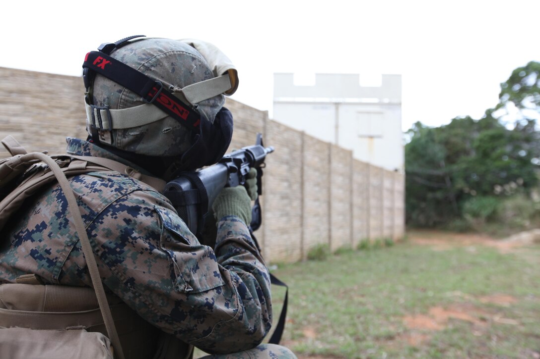 A Marine with 3rd LE Bn. prepares to return fire Jan. 16 during MOUT training in the Central Training Area. During the training event, Marines used simulated rounds to mimic combat operations in a controlled environment.
