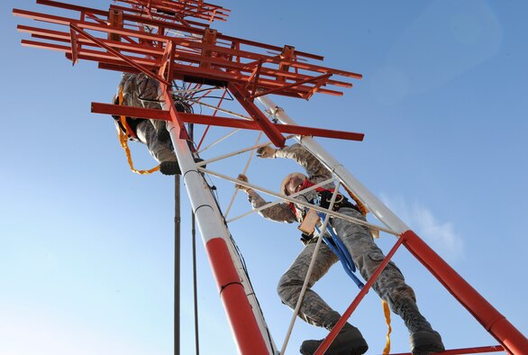 YOKOTA AIR BASE, Japan -- Senior Airman Jason Badia and Lucas Dugan, 374th Communications Squadron airfield systems technicians, climb a glide slope antenna at Yokota Air Base, Japan, Jan. 17, 2014. Airfield systems Airmen checked the antenna to ensure that there are no signs of failure or corrosion. (U.S. Air Force photo by Staff Sgt. Andrea Salazar)