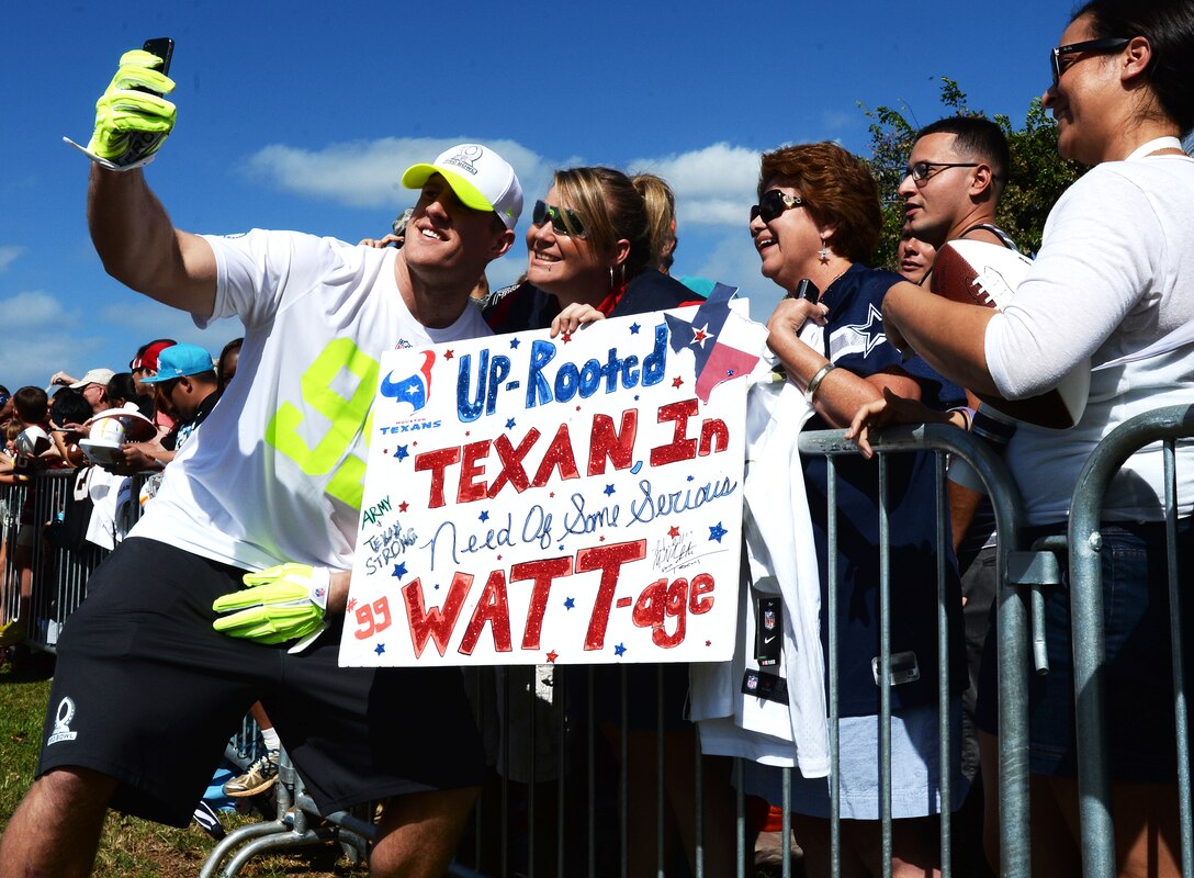 Houston Texans Defensive End J.J. Watt poses for a “selfie” with Kari Livanec after an Official National Football League Pro Bowl Practice on Earhart Field at Joint Base Pearl Harbor-Hickam, Hawaii, Jan. 23, 2014. The players were at JBPHH to practice for the Pro Bowl football game at Aloha Stadium in Honolulu, Hawaii, Jan. 26. Joint Base community members, many wearing their favorite NFL gear, lined the field sidelines to get a glimpse of their favorite player(s). (U.S. Air Force photo/Staff Sgt. Alexander Martinez)