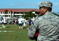 Chief Master Sgt. Marlin Hill, Pacific Air Forces enlisted functional manager, watches Team Sanders football players practice during an Official National Football League Pro Bowl Practice on Earhart Field at Joint Base Pearl Harbor-Hickam, Hawaii, Jan. 23, 2014. The players were at JBPHH to practice for the Pro Bowl football game at Aloha Stadium in Honolulu, Hawaii, Jan. 26. Joint Base community members, many wearing their favorite NFL gear, lined the field sidelines to get a glimpse of their favorite player(s). (U.S. Air Force photo/Staff Sgt. Alexander Martinez)