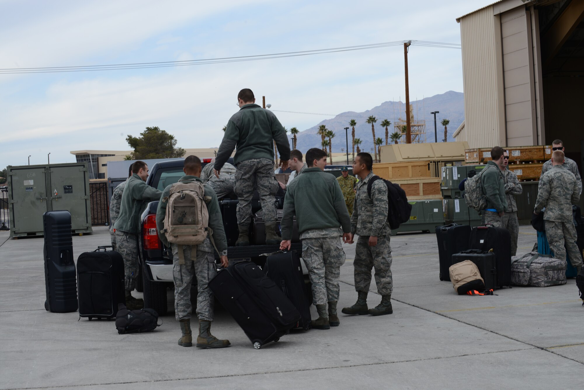 Airmen from the 366th Fighter Wing load luggage onto a truck Jan. 23, 2013, at Nellis Air Force Base, Nev. The Airmen are stationed at Mountain Home Air Force Base, Idaho, and are here participating in Red Flag 14-1. (U.S. Air Force photo by Senior Airman Benjamin Sutton/Released)