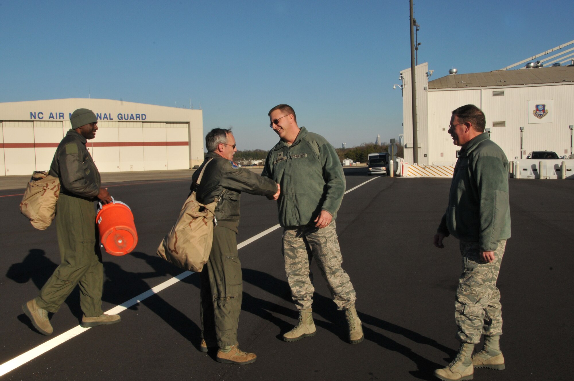 U.S. Air Force Col. Roger E. Williams, Jr., Commander, 145th Airlift Wing, congratulates Senior Master Sgt. Philip H. Smith after Smith completed his final, or fini flight, onboard a 145th AW C-130 Hercules aircraft after serving more than 35 years in the military, 24 of those years were as a tactic loadmaster for the 156th Airlift Squadron.  Smith’s fini flight was held at the North Carolina Air National Guard base, Charlotte-Douglas Intl. airport, January 16, 2014 in honor of his retirement.  (Air National Guard photo by Master Sgt. Patricia F. Moran, 145th Public Affairs/Released)