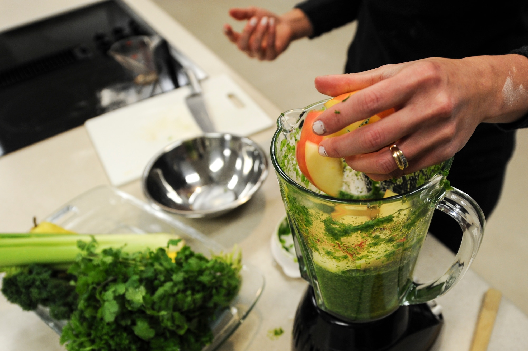 Angela Peralta, Buckley Health and Wellness Center registered dietitian, blends fruits and vegetables into a smoothie during a healthy cooking class Jan. 17, 2014, at the HAWC on Buckley Air Force Base, Colo. Peralta demonstrated to several Team Buckley members how to make healthy smoothies and pastries during the class. (U.S. Air Force photo by Airman Emily Amyotte/Released)