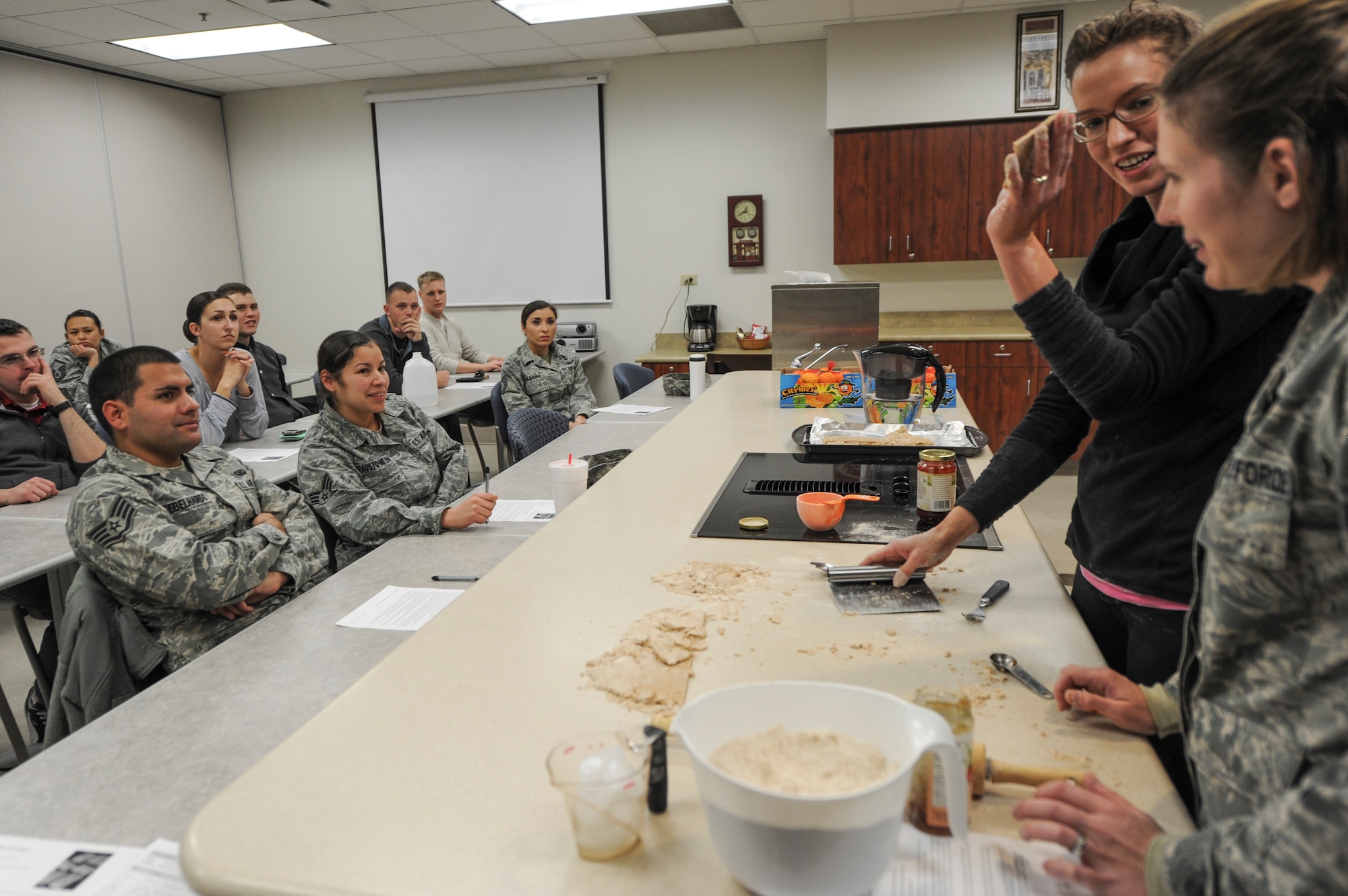 Angela Peralta, Buckley Health and Wellness Center registered dietitian, standing left, and Staff Sgt. Tonya Woosley, Air Reserve Personnel Center, standing right, demonstrate how to make pastries during a healthy cooking class Jan. 17, 2014, at the HAWC on Buckley Air Force Base, Colo. Woosley was one of several Team Buckley members who attended the class taught by Peralta. (U.S. Air Force photo by Airman Emily Amyotte/Released)