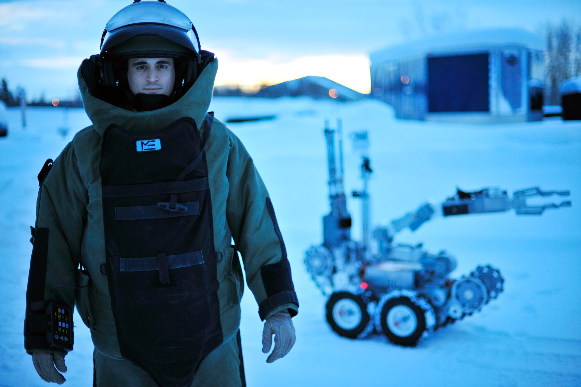 U.S. Air Force Staff Sgt. Joseph Riemer, 354th Civil Engineer Squadron explosive ordnance disposal technician, stands by an F6A robot in an EOD 9 bomb suit Jan. 21, 2014, Eielson Air Force Base, Alaska. Riemer has been nominated for the NCOA Vanguard Award and the 2013 354th Fighter Wing NCO of the Year. The NCOA Vanguard Award recognizes enlisted members who perform a heroic act, on or off duty, which result, in saving lives or preventing injury. (U.S. Air Force Photo by Staff Sgt. Jim Araos/Released)