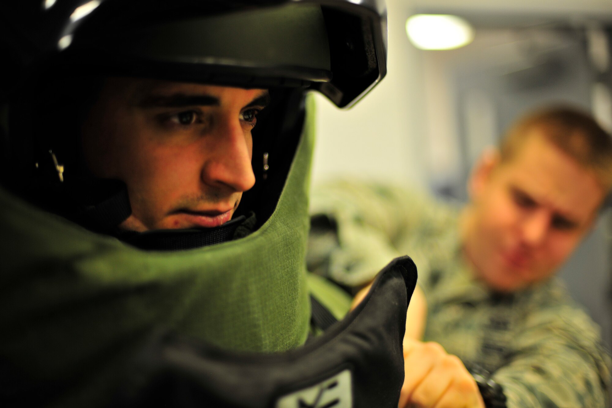 U.S. Air Force Staff Sgt. Joseph Riemer, 354th Civil Engineer Squadron explosive ordnance disposal technician, receives assistance donning his EOD 9 bomb suit Jan. 21, 2014, Eielson Air Force Base, Alaska. The EOD 9 bomb suit is designed to withstand the pressure released from an explosive device and shrapnel produced. (U.S. Air Force photo by Staff Sgt. Jim Araos/Released)