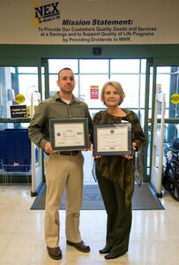 Beth Munoz, Joint Base Charleston – Weapons Station Navy Exchange general manager, stands with Alex Schmidt, NEX loss prevention manager, as they display Munoz’s Patriotic Employer and Above and Beyond Awards from Employer Support of the Guard and Reserve Jan. 22, 2014, at the NEX on the Weapons Station. (U.S. Air Force photo by Airman 1st Class Clayton Cupit)