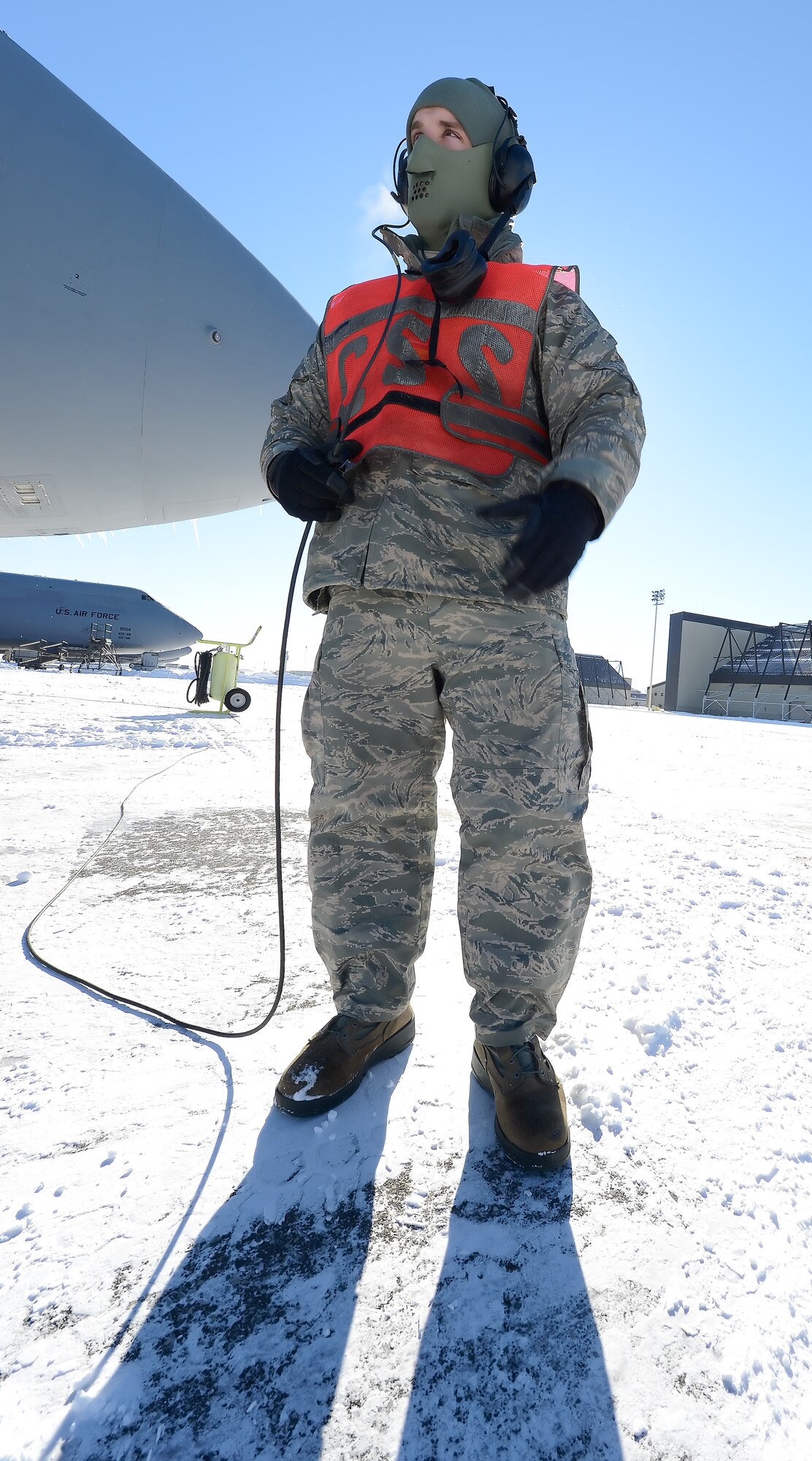 Airman 1st Class Jack Grimmett, 436th Aircraft Maintenance Squadron stands on a snow-covered flightline while monitoring the engine run of a C-5M Super Galaxy during a bleed-air operational check, Jan. 22, 2014, at Dover Air Force Base, Del. As Grimmett exhales his breath can be seen due to the extreme cold. (U.S. Air Force photo/Greg L. Davis)