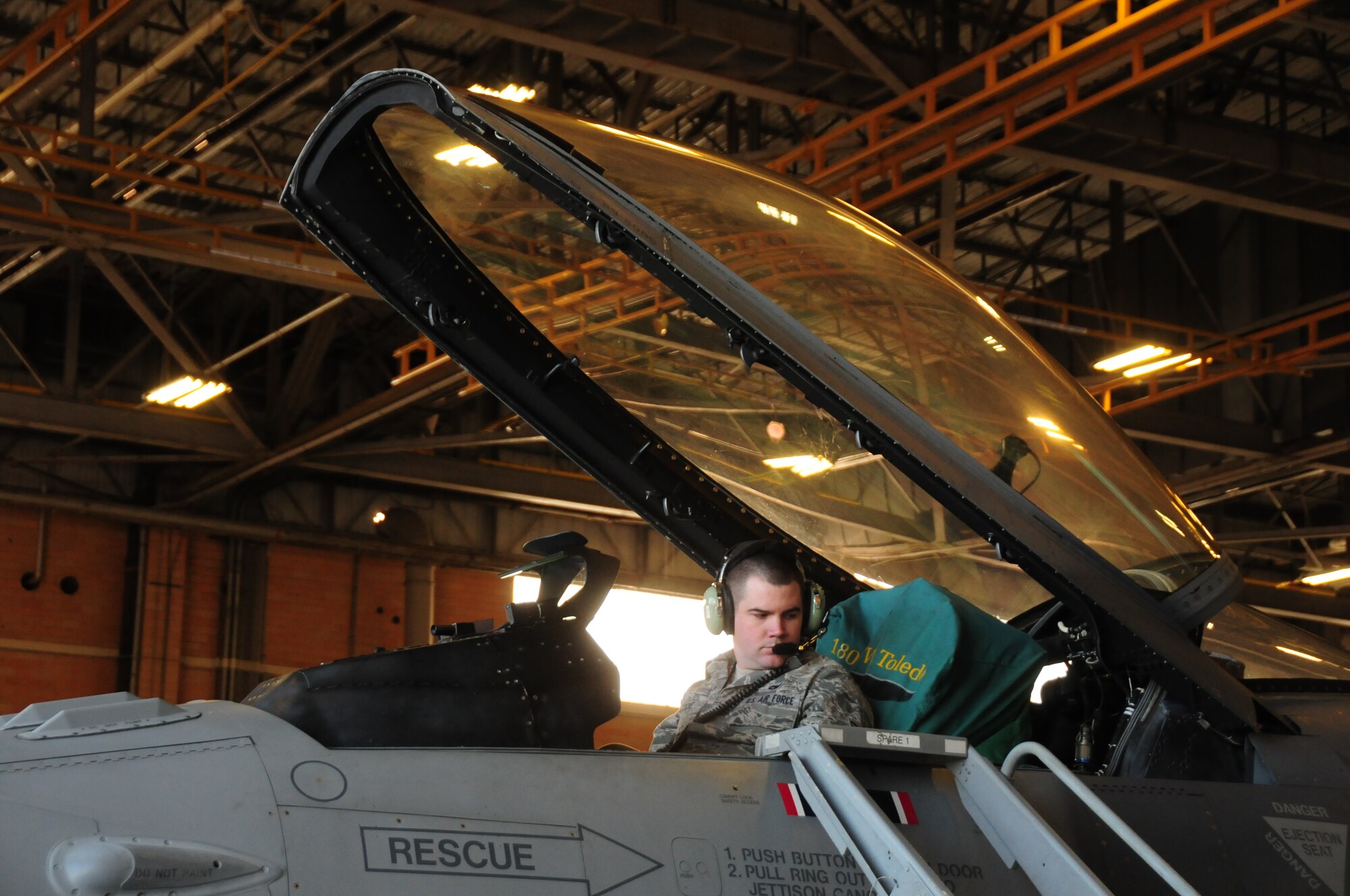 180th Fighter Wing Crew Chief, Senior Airman Andy Cocke controls the hydraulics while other Airmen repair the landing gear of an F-16 Fighting Falcon at Joint Reserve Base New Orleans, New Orleans, La.  Jan. 16, 2014.  The 180th Fighter Wing is currently participating in a training exercise with F-15 Screaming Eagles from the 159th FW, New Orleans Air National Guard.  The purpose of this training is to aid pilots in maintaining familiarity with capabilities of different fighter aircraft.  The 180th’s F-16s are a multi-role aircraft whereas the F-15s conduct mainly air-to-air missions. (Ohio Air National Guard photo by Staff Sgt. Amber Williams/Released)