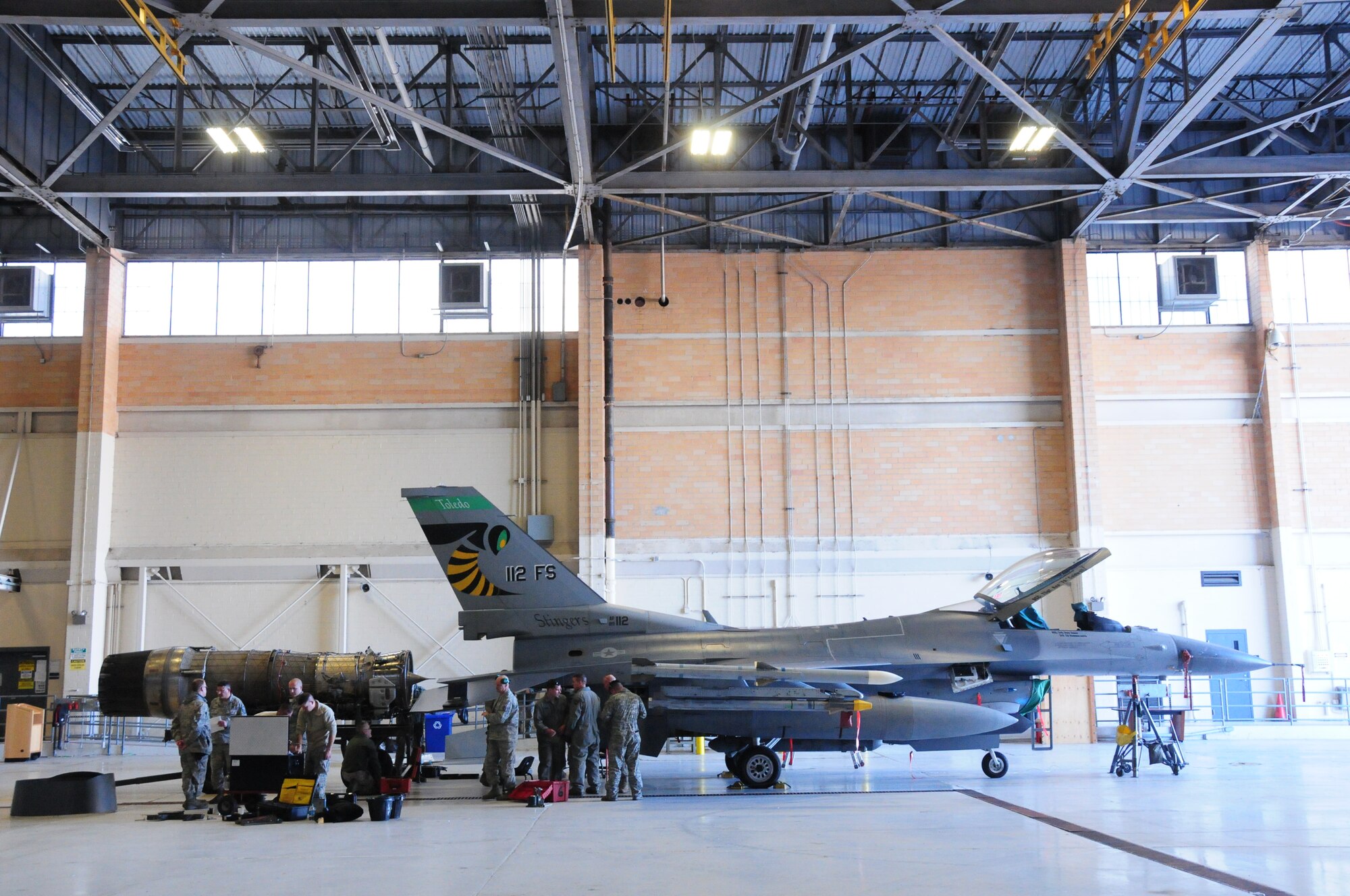 Crew Chiefs from the 180th Fighter Wing, Toledo, Ohio remove a Pratt and Whitney 229 engine from an F-16 at Joint Reserve Base New Orleans, New Orleans, La.  Jan. 16, 2014.  The 180th Fighter Wing is currently participating in a training exercise with F-15 Screaming Eagles from the 159th FW, New Orleans Air National Guard.  The purpose of this training is to aid pilots in maintaining familiarity with capabilities of different fighter aircraft.  The 180th’s F-16s are a multi-role aircraft whereas the F-15s conduct mainly air-to-air missions. (Ohio Air National Guard photo by Staff Sgt. Amber Williams/Released)