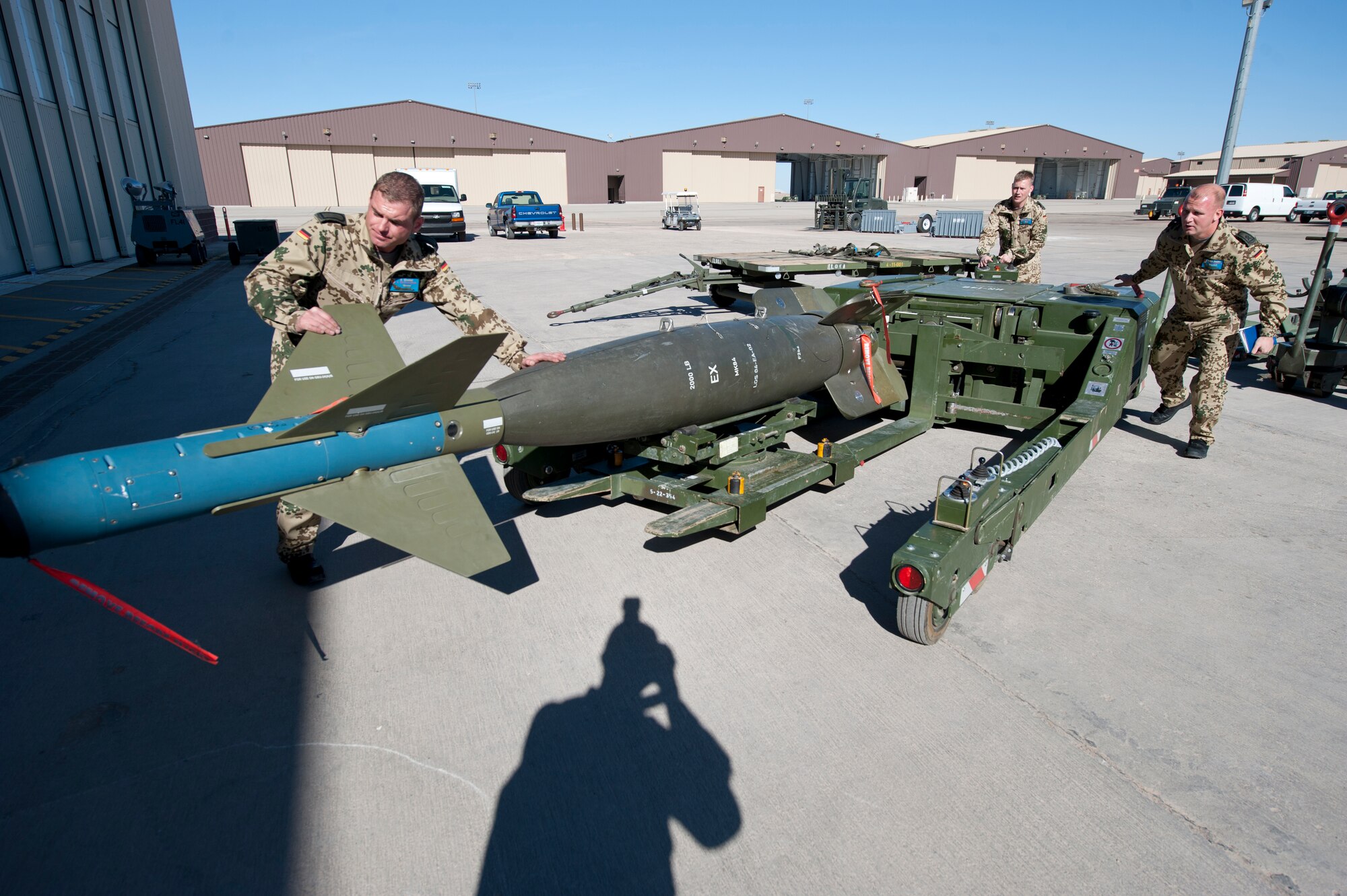 Master Sgt. Torsten Naujoks, Staff Sgt. Oliver Simmler and Staff Sgt. Christian Berg, all German Air Force Flying Training Center crew chiefs, prepare an inert missile for a Tornado jet during a quarterly load crew competition at Holloman Air Force Base, N.M., Jan. 17. The GAF competed in the load crew competition to have their skills evaluated alongside the F-22 Raptor and MQ-9 Reaper load crews. For the competition, points are awarded during the weapons loading, tool kit inspection and uniform inspection. (U.S. Air Force photo by Senior Airman Daniel Liddicoet/Released)