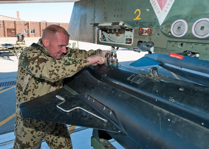 Master Sgt. Torsten Naujoks , German Air Force Flying Training Center crew chief, guides an inert missile toward a Tornado jet during a quarterly load-crew competition at Holloman Air Force Base, N.M., Jan. 17. The GAF competed in the load-crew competition to have their skills evaluated alongside the F-22 Raptor and MQ-9 Reaper load crews. For the competition, points are awarded during the weapons loading, tool kit inspection and uniform inspection. (U.S. Air Force photo by Senior Airman Daniel Liddicoet/Released)