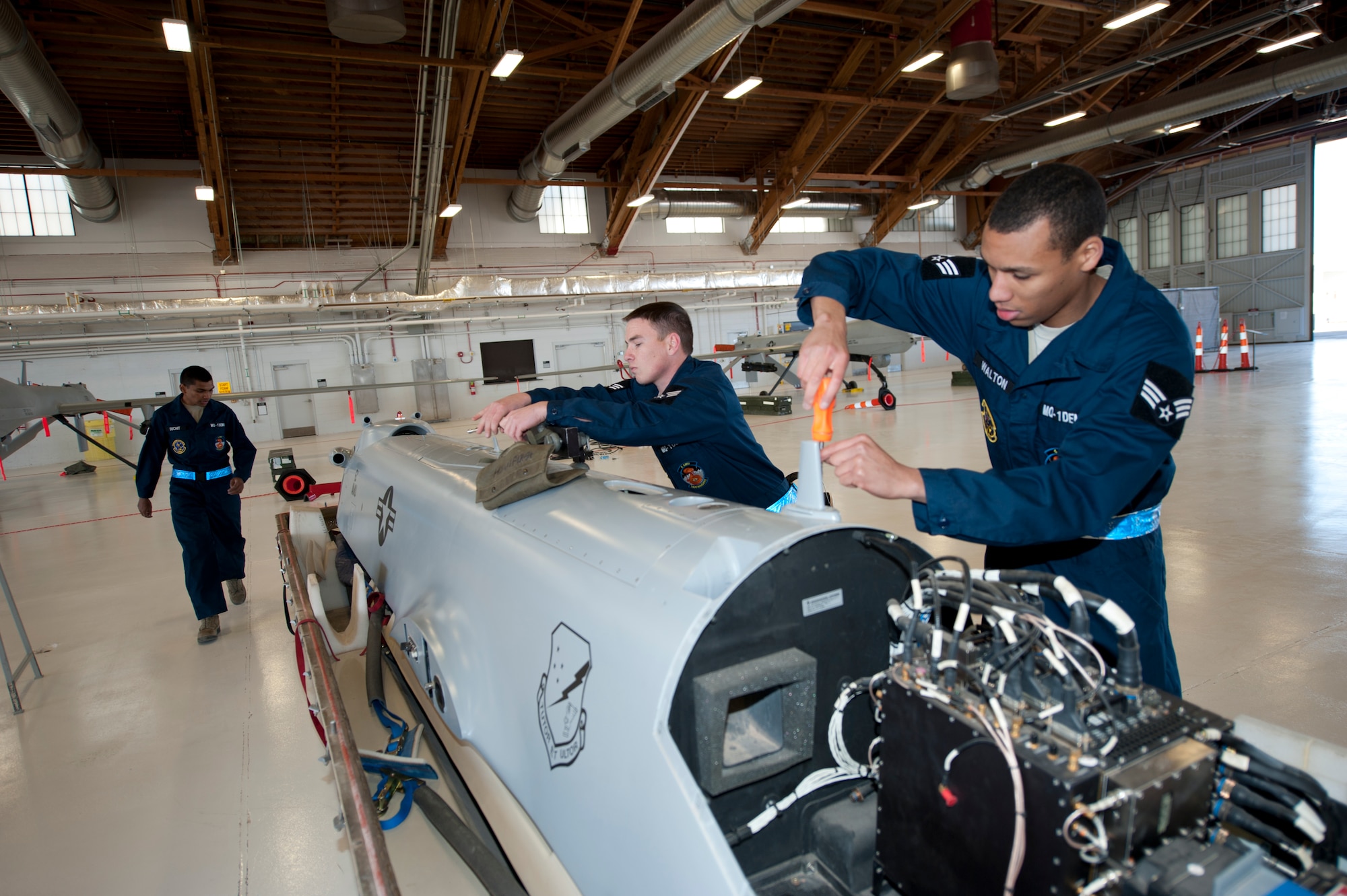 The MQ-1 Predator build team assembles the aircraft at Holloman Air Force Base, N.M., Jan. 17. The MQ-1 build team demonstrates the airmen’s ability to build an prepare an MQ-1 after delivery. The build team travels to different locations to showcase the expedient process of assembly, which on average takes just over half an hour to complete. (U.S. Air Force by Senior Airman Daniel Liddicoet/Released)