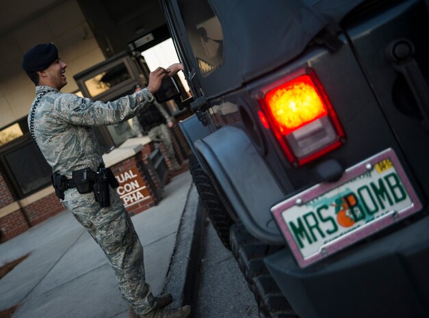 Airman 1st Class Trey Weston, 628th Security Forces Squadron entry controller to search, checks an individual’s identification to determine if they can access the base Dec. 22, 2013, at Joint Base Charleston – Air Base, S.C. Weston performed night patrol where he manned the gate, set-up radar check points and building security checks. (U.S. Air Force photo/ Senior Airman Dennis Sloan)